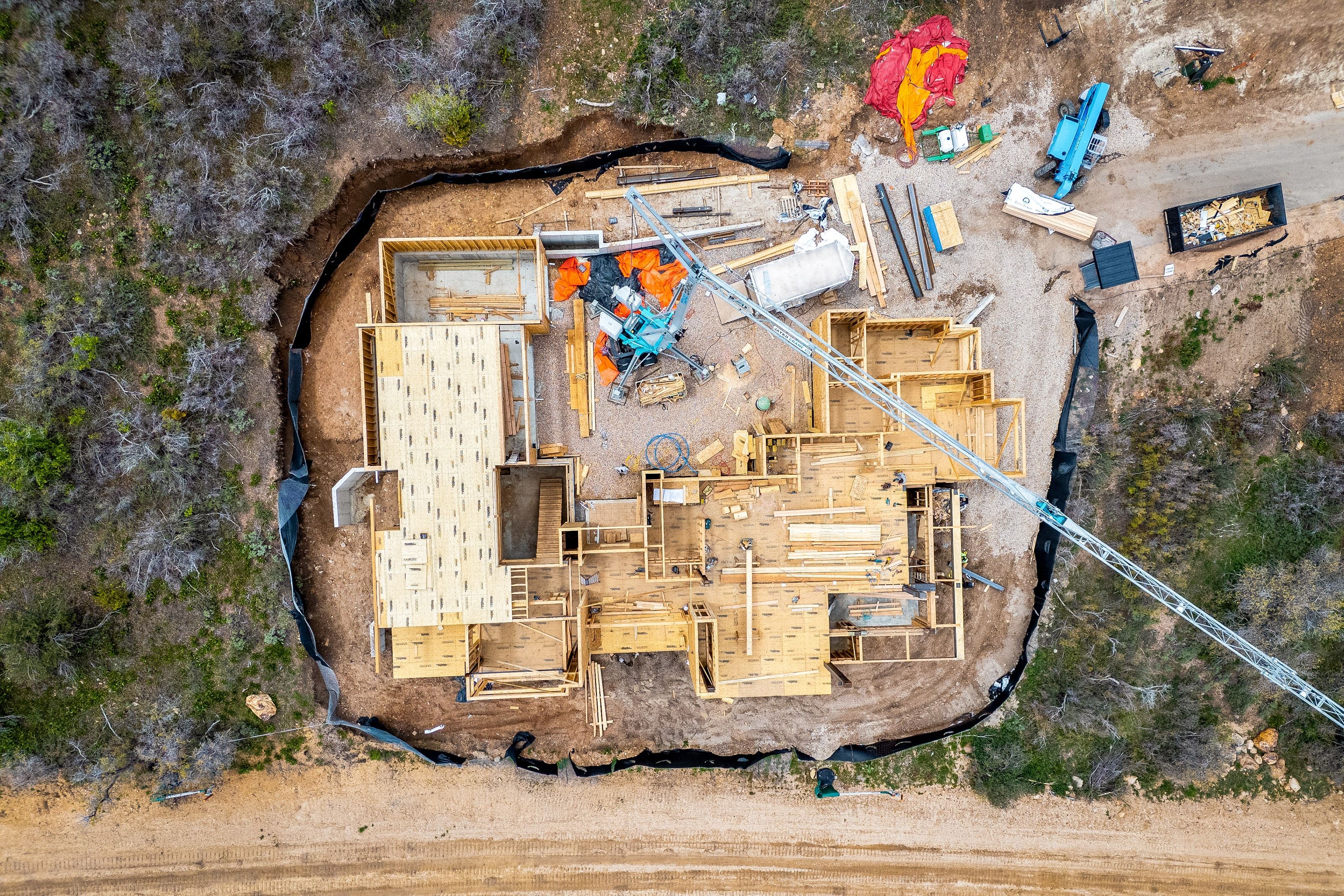 New construction site featuring a partially framed structure with a large footprint