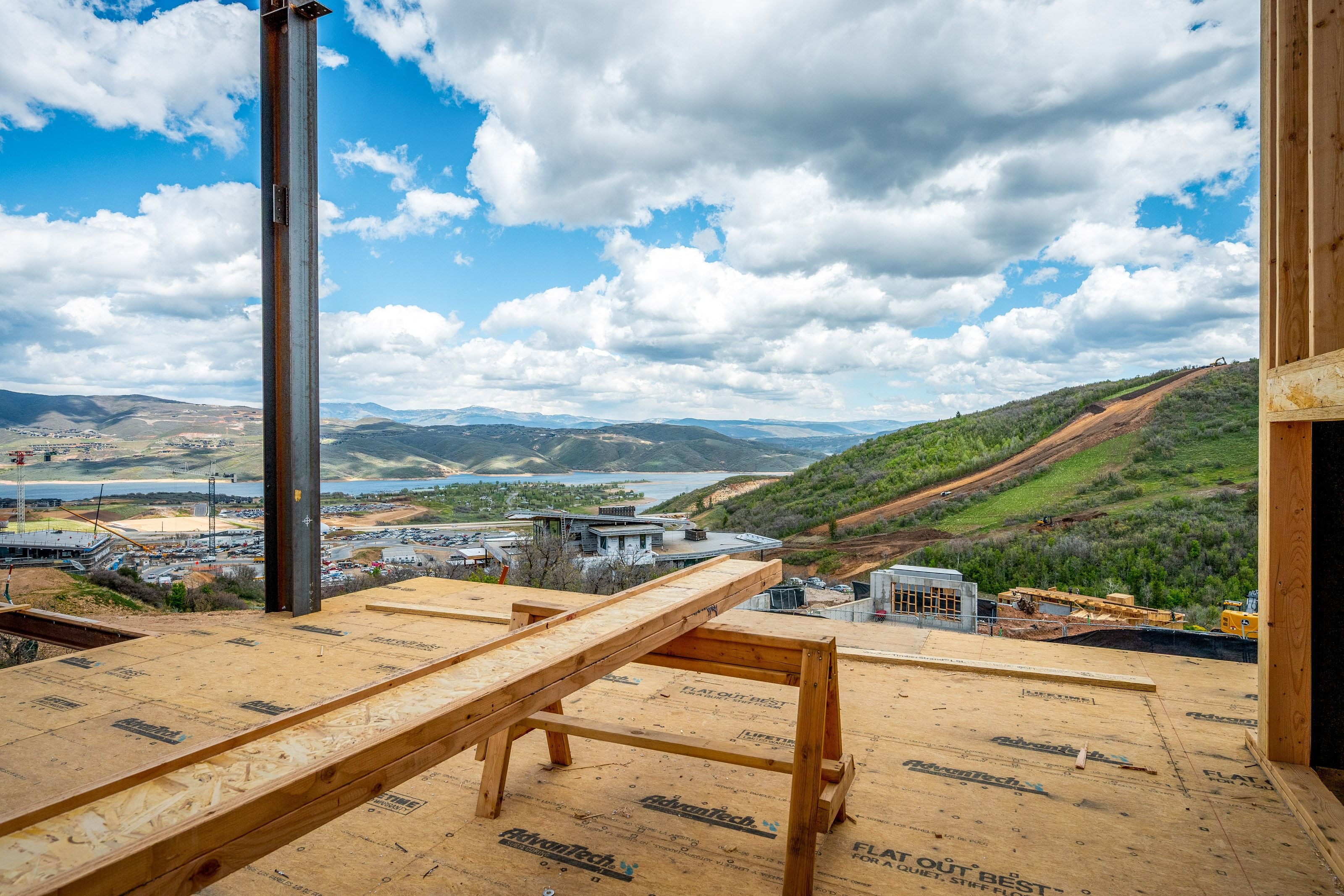 Expansive open-air construction platform featuring a substantial steel support beam and wood framing