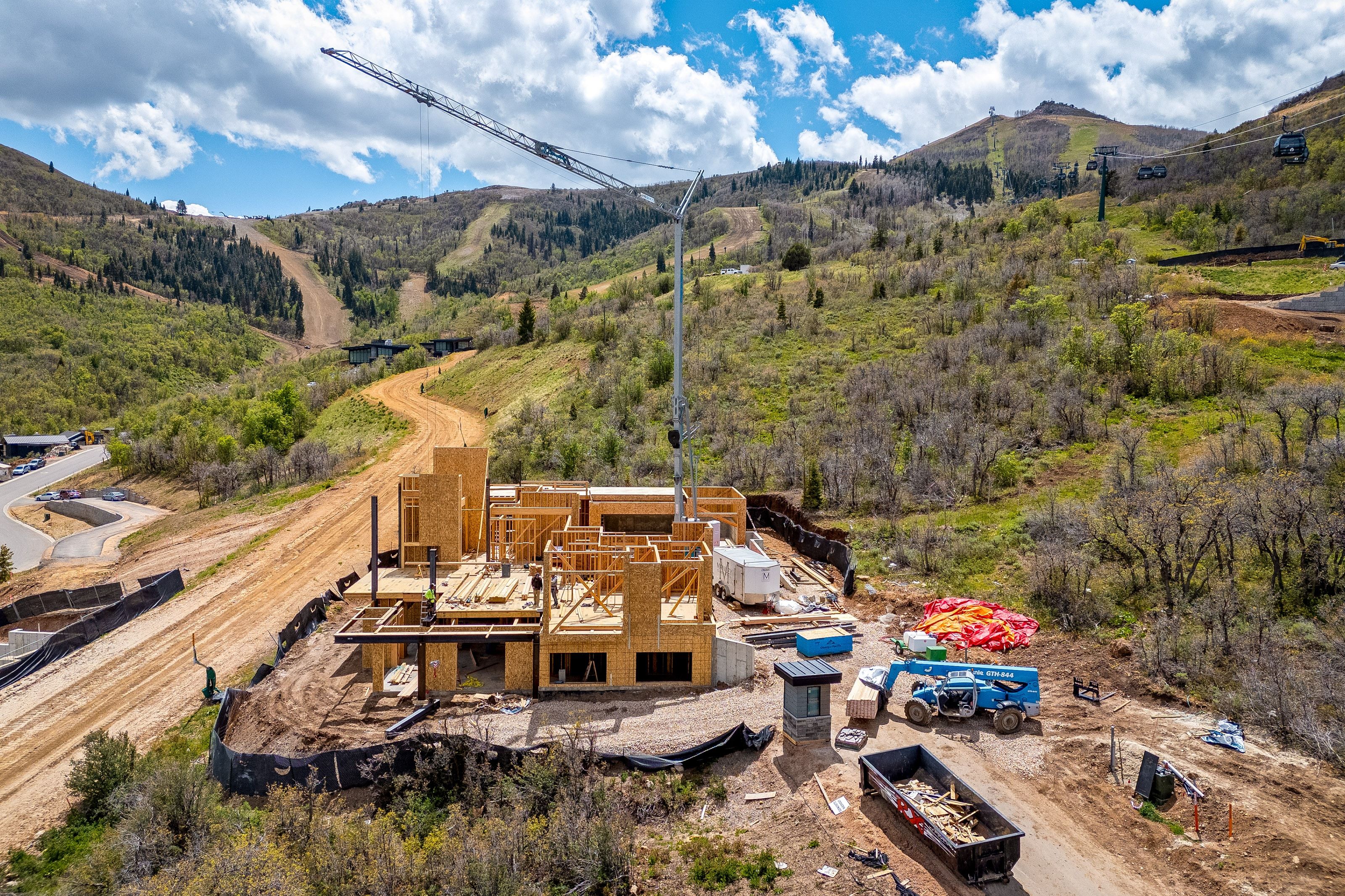 New construction framing situated on a hillside lot with mountain terrain