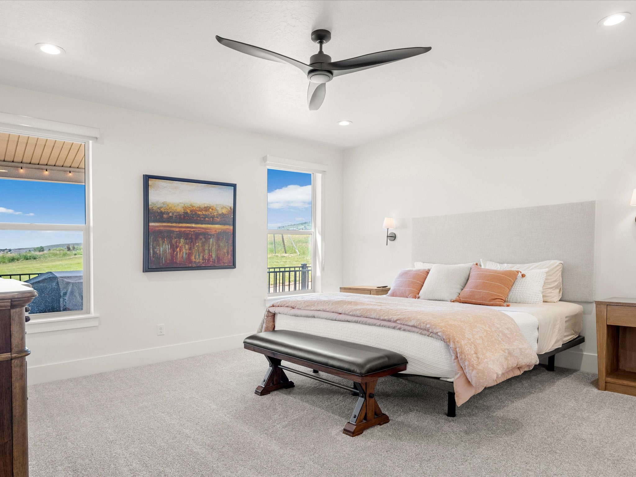Spacious sleeping area featuring light gray carpeting, recessed lighting, and a contemporary ceiling fan