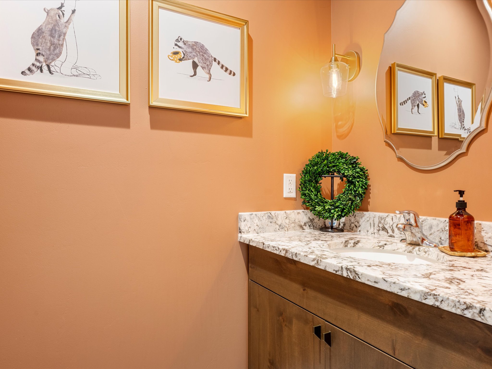 Bathroom vanity featuring a light-toned countertop, undermount sink, and wood-finish cabinetry