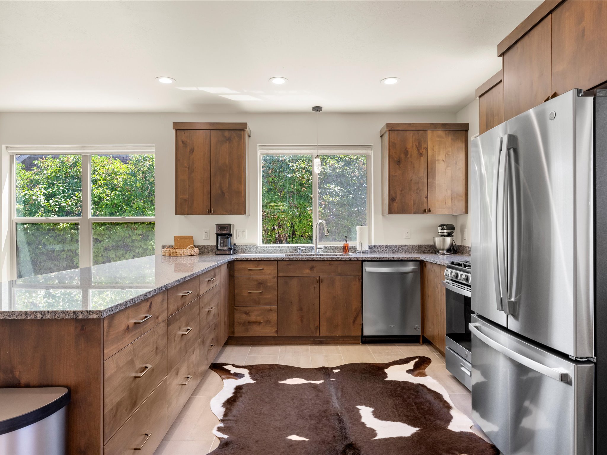 Kitchen featuring granite countertops, wood cabinetry, stainless steel appliances, and recessed lighting