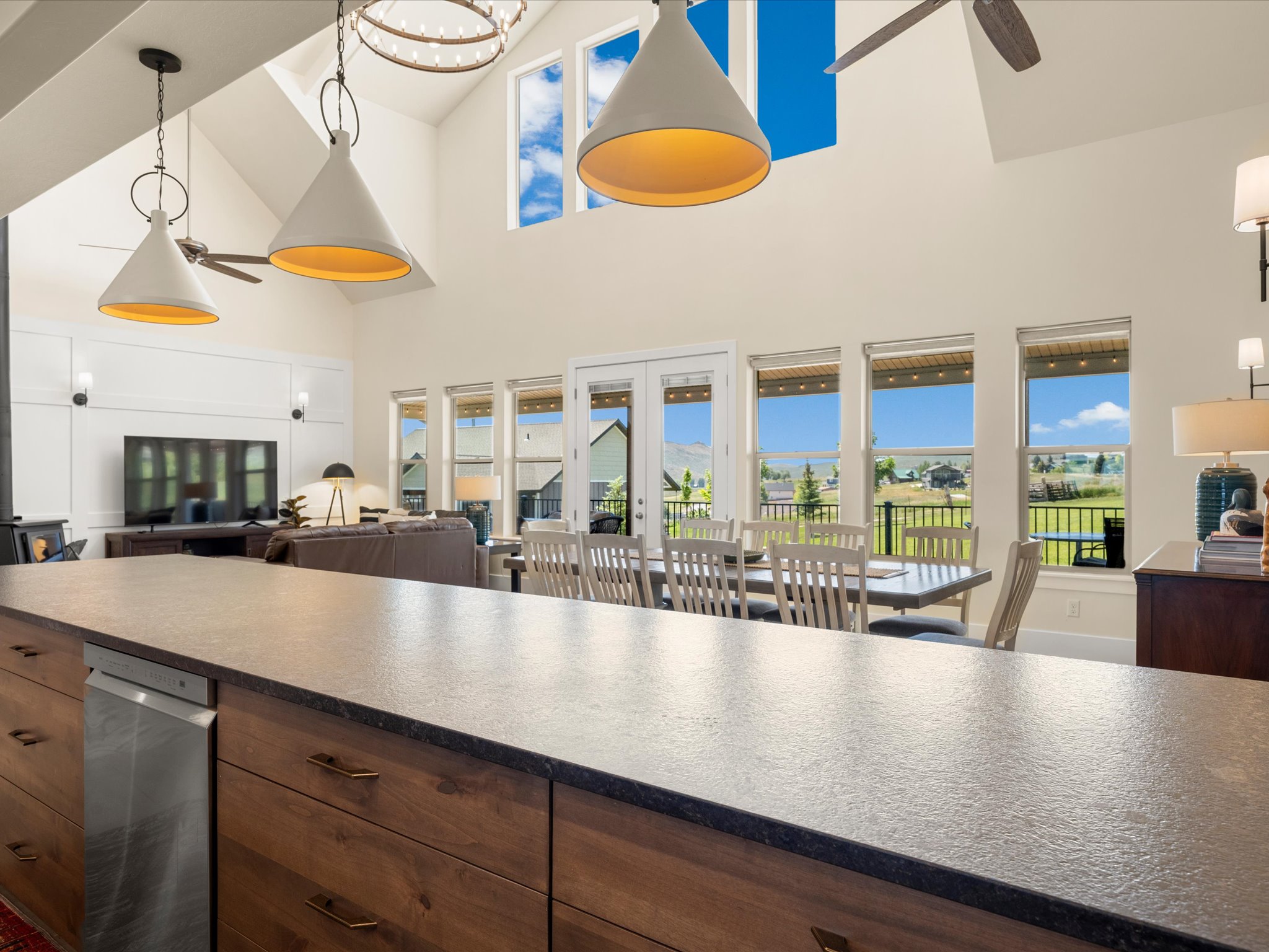 Expansive kitchen island with a dark stone-finish countertop and wood-finish cabinetry