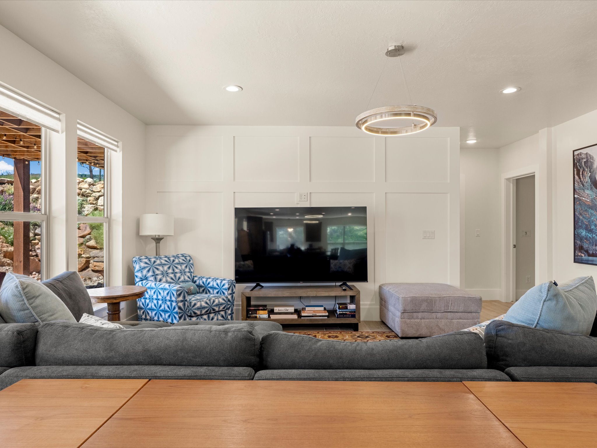 Bright living area featuring a decorative wainscoting accent wall, recessed lighting, and a contemporary circular ceiling fixture