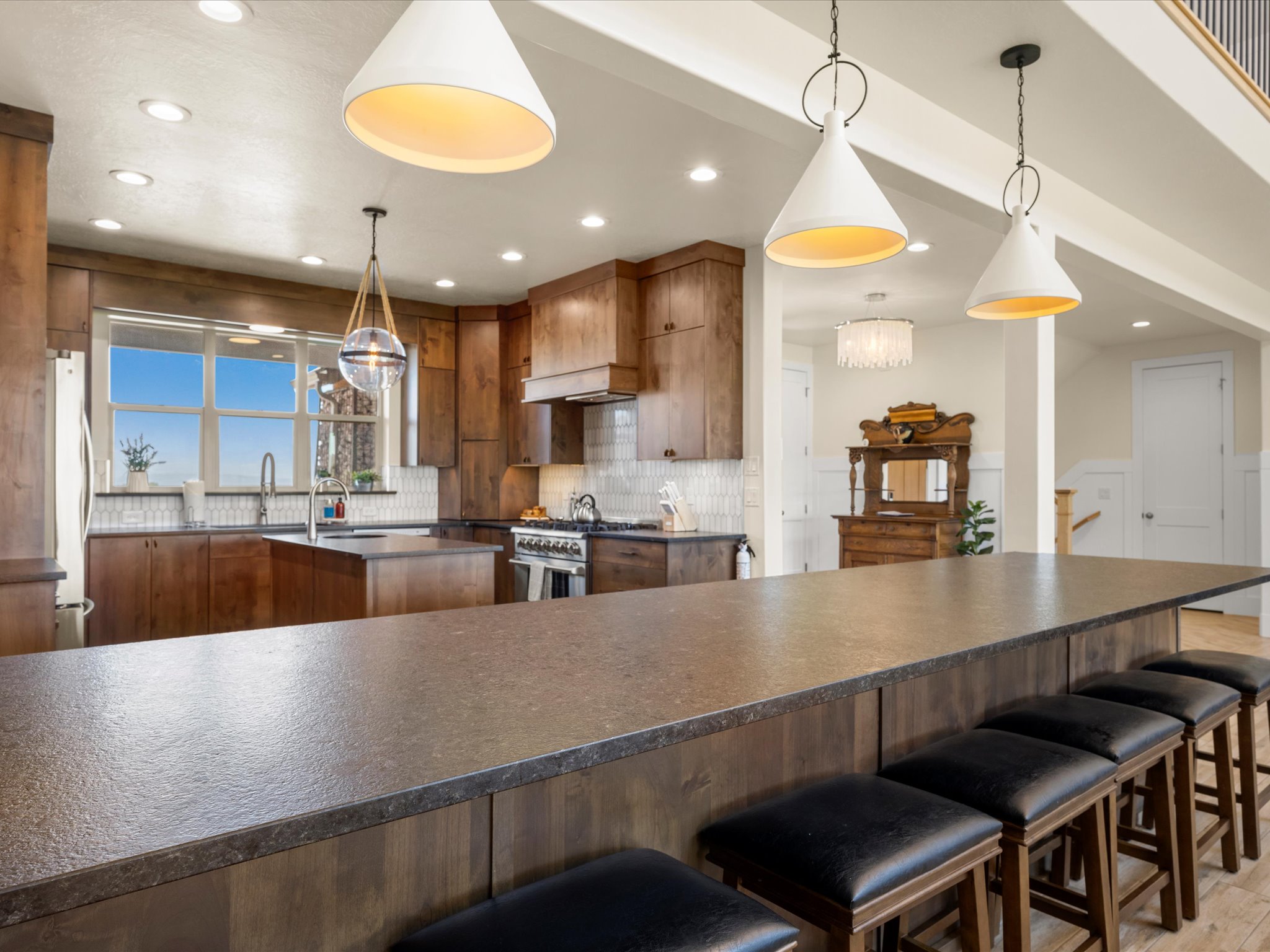 Expansive kitchen island with seating, complemented by warm wood-finish cabinetry and light-toned countertops