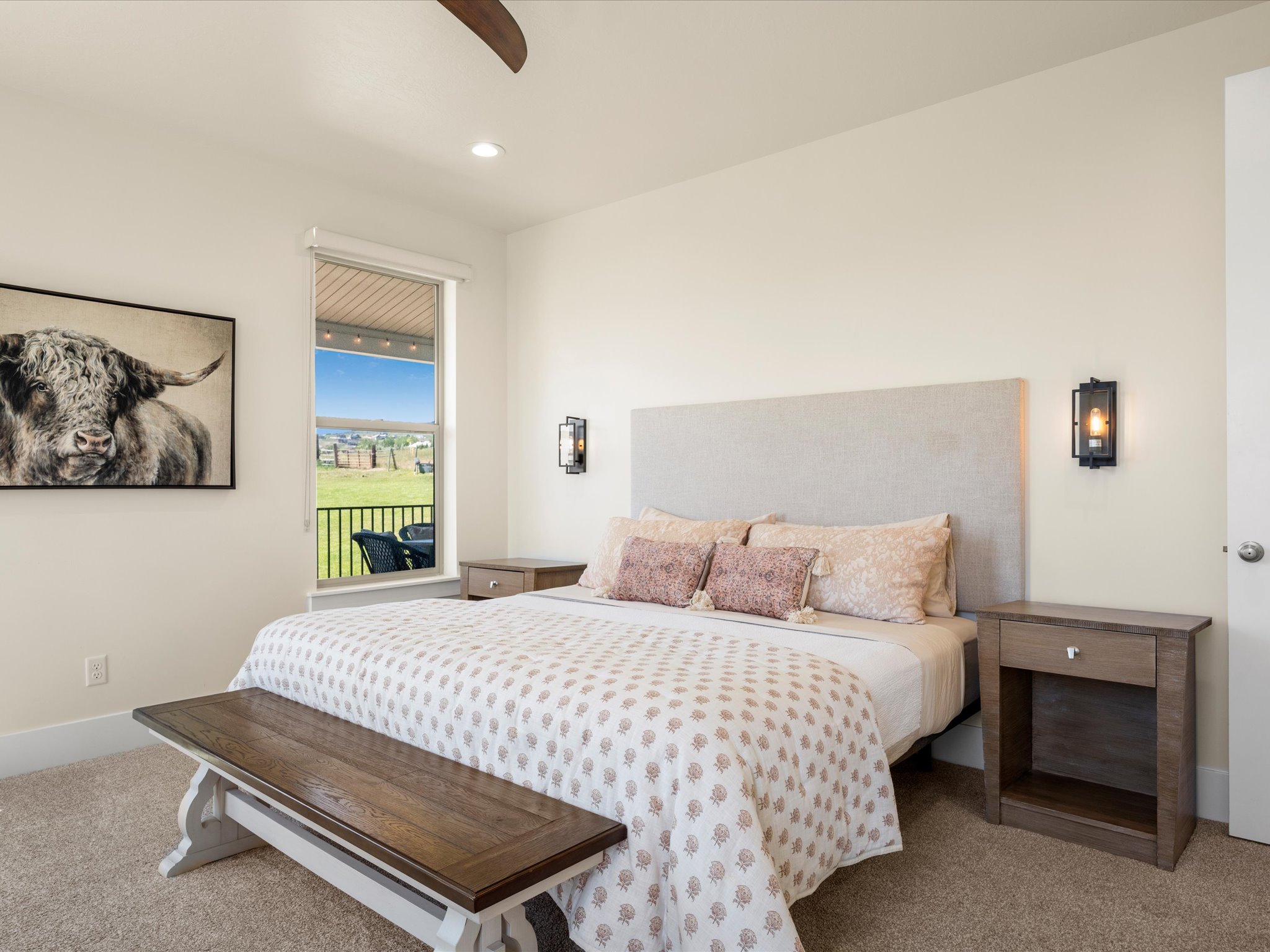 Carpeted bedroom featuring recessed lighting, a ceiling fan, and a window overlooking a covered patio and green landscape