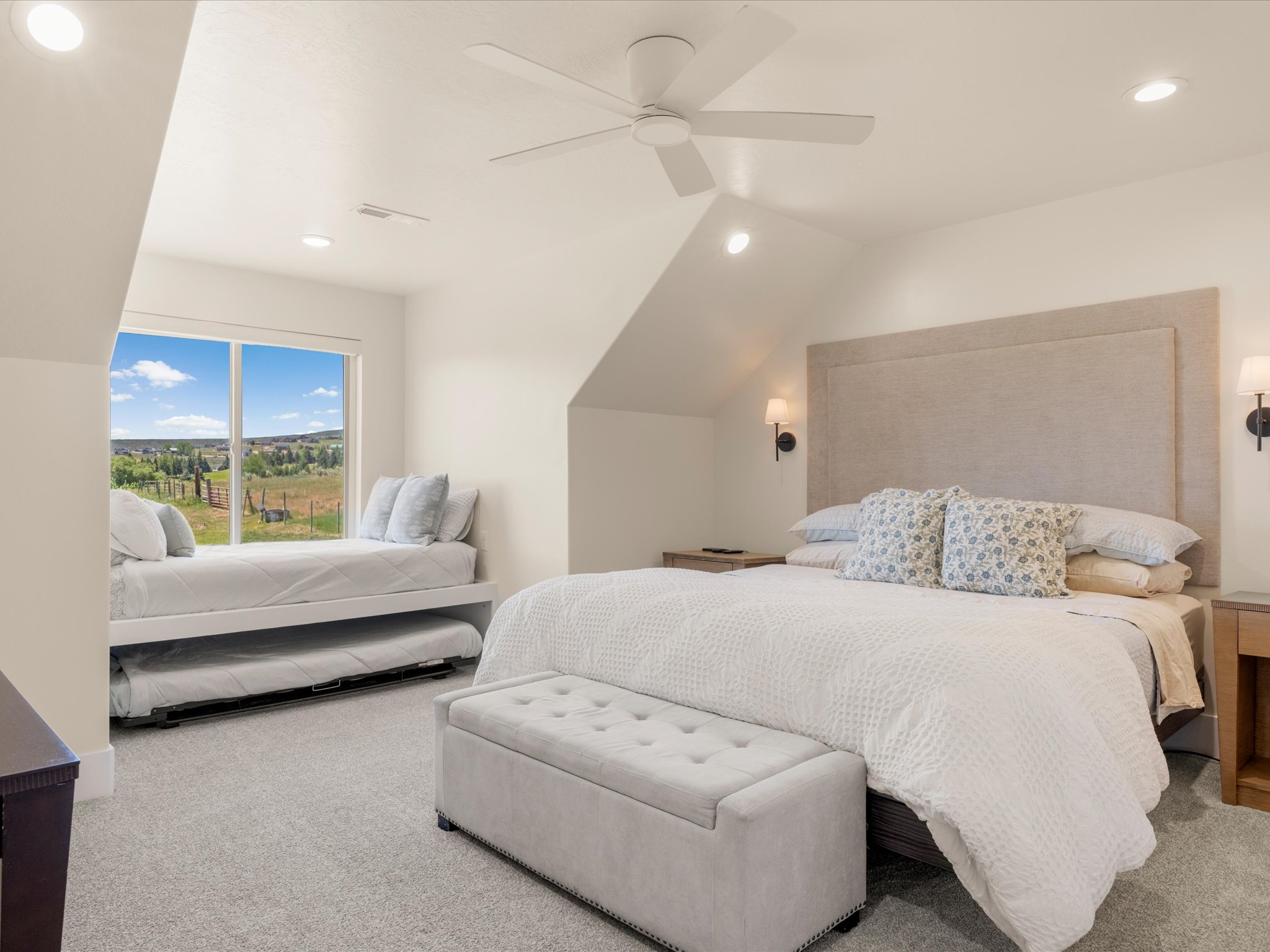Spacious room featuring vaulted ceilings, recessed lighting, and a large window
