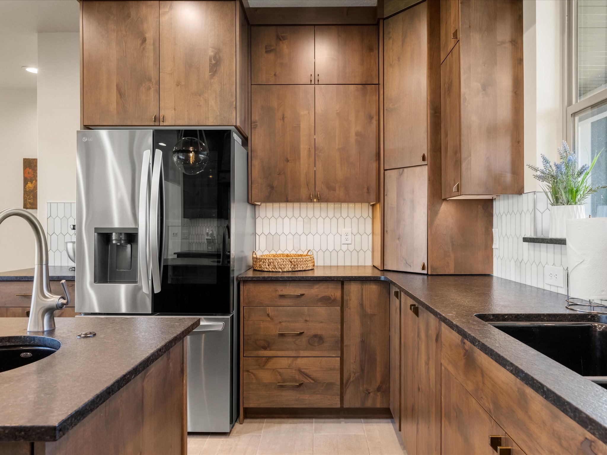 Kitchen featuring wood-finish cabinetry, dark countertops, and a full-height picket-tile backsplash