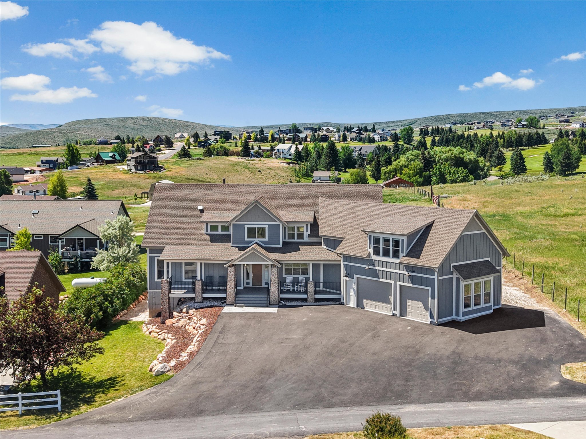 Contemporary-style residence featuring a multi-gable roofline and grey siding