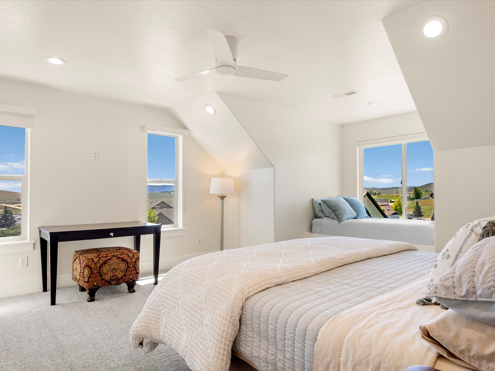 Bright room with white walls, a built-in window bench, light gray carpeting, recessed lighting, and a ceiling fan
