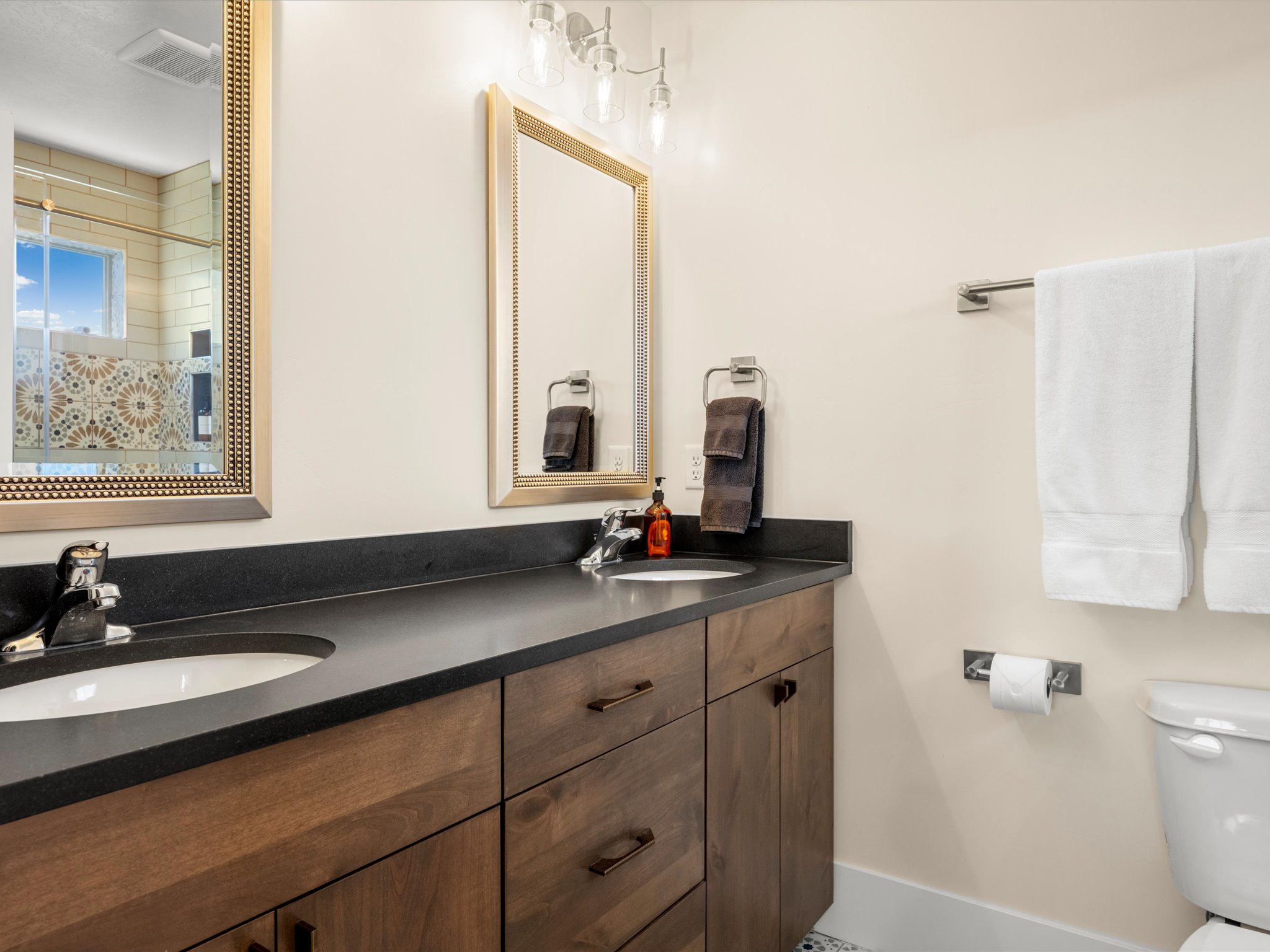 Double vanity featuring undermount sinks and dark countertops