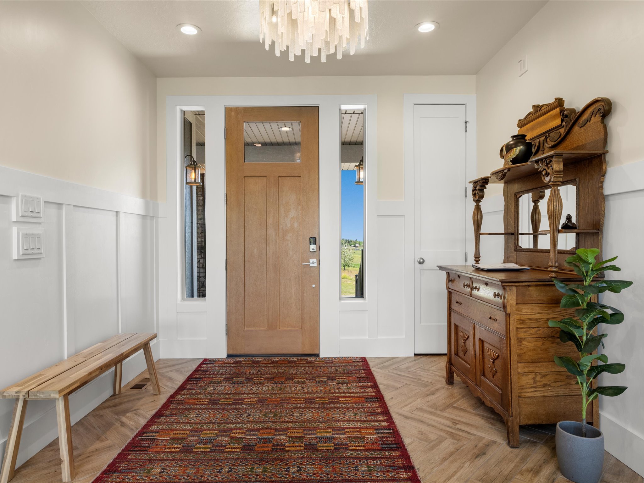 Entryway featuring wood-finish tile flooring, wainscoting, and a natural wood door with glass paneling