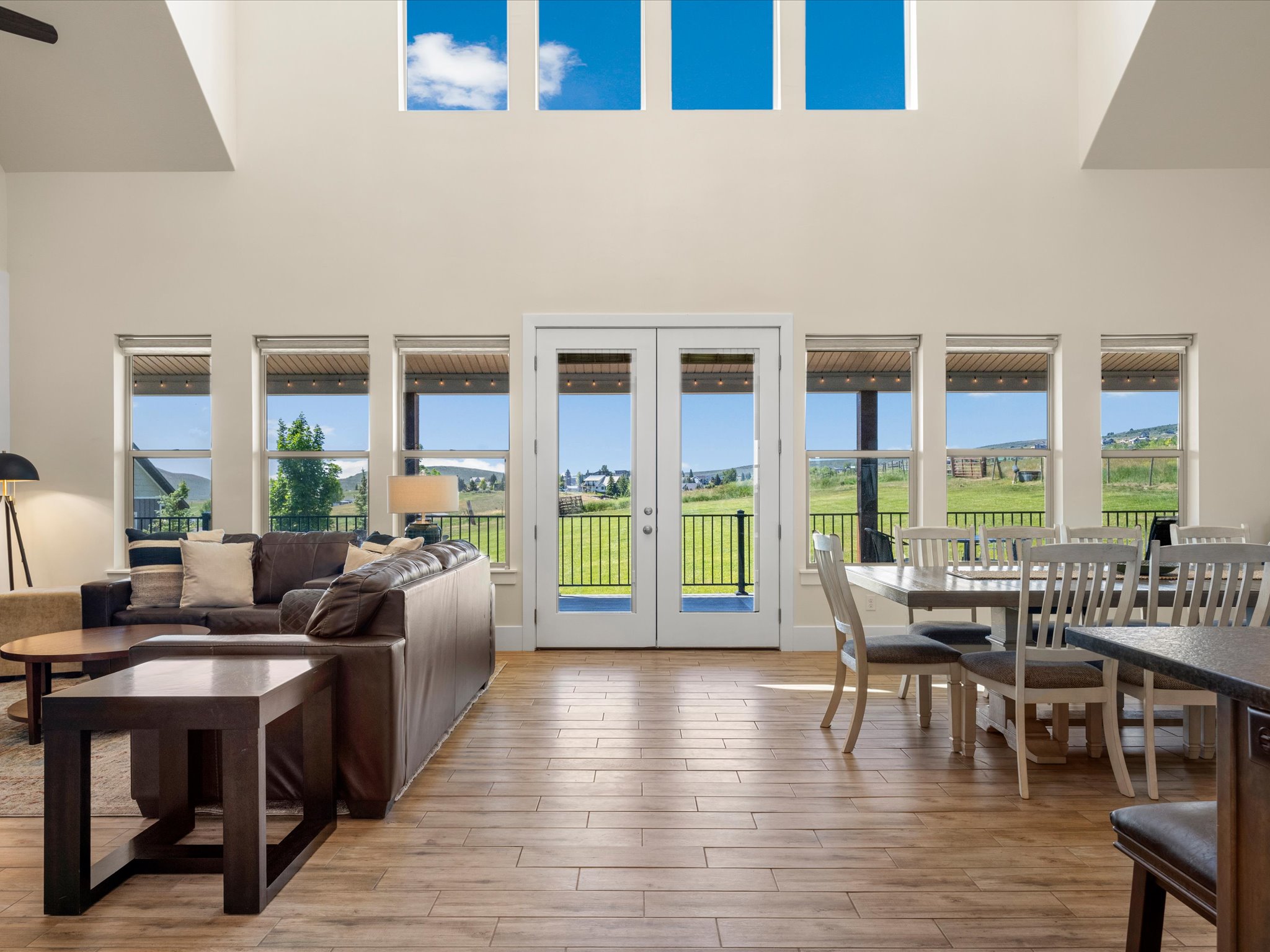 Spacious open-concept interior featuring high ceilings, wood-finish tile flooring, and white walls