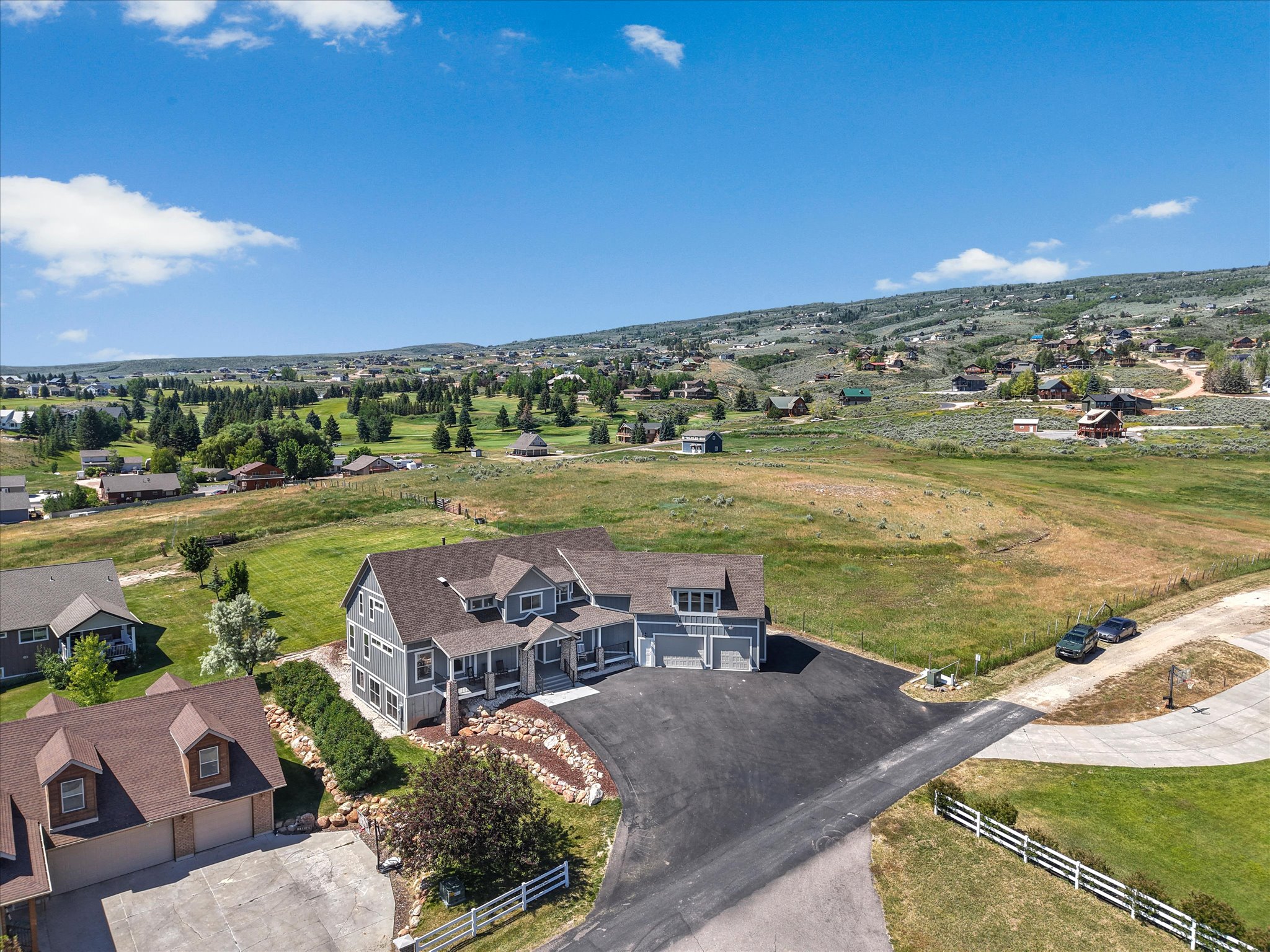 Expansive property featuring a multi-level home with gray siding and multiple gables