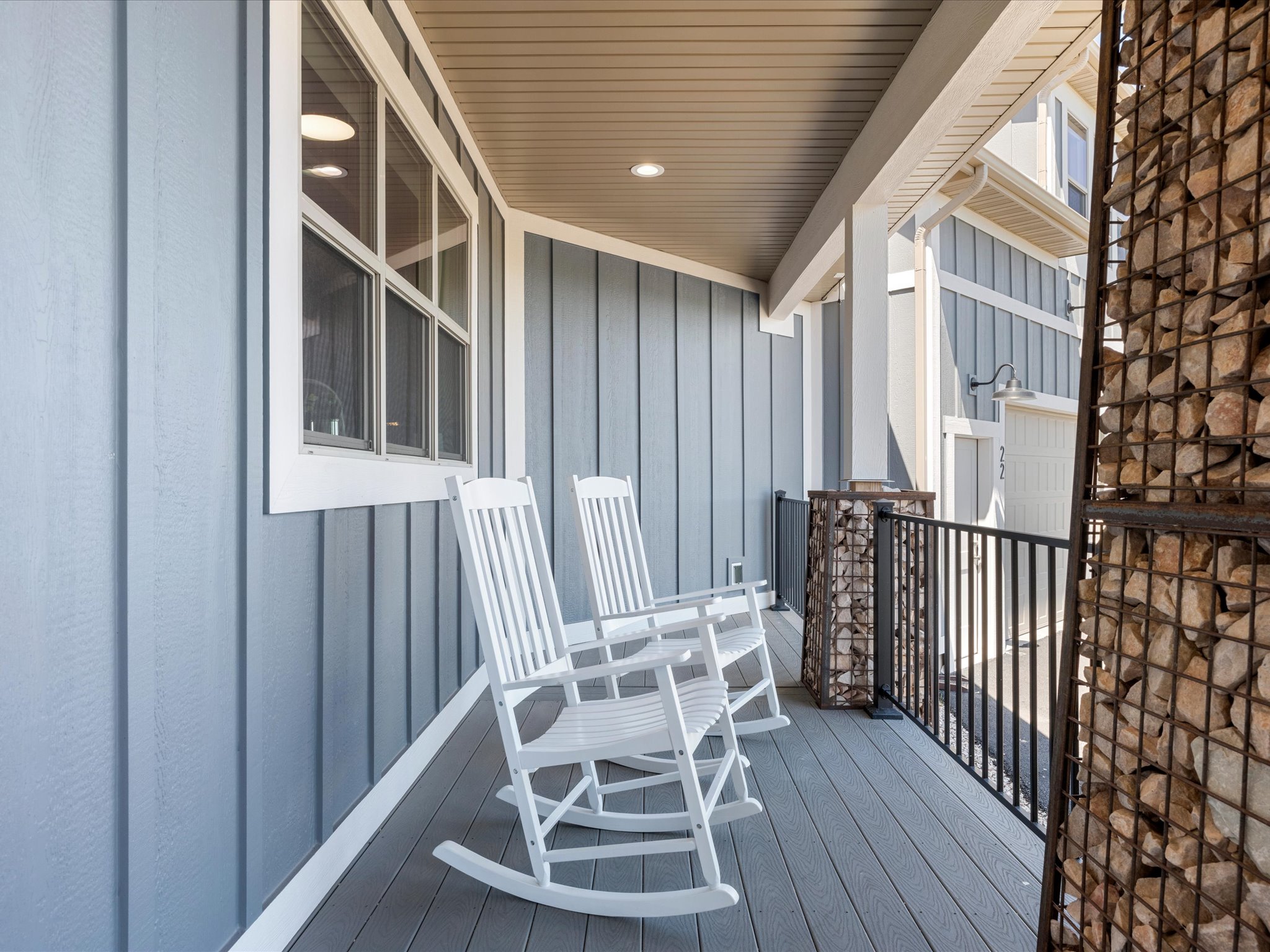 Covered porch featuring vertical plank siding and a composite deck