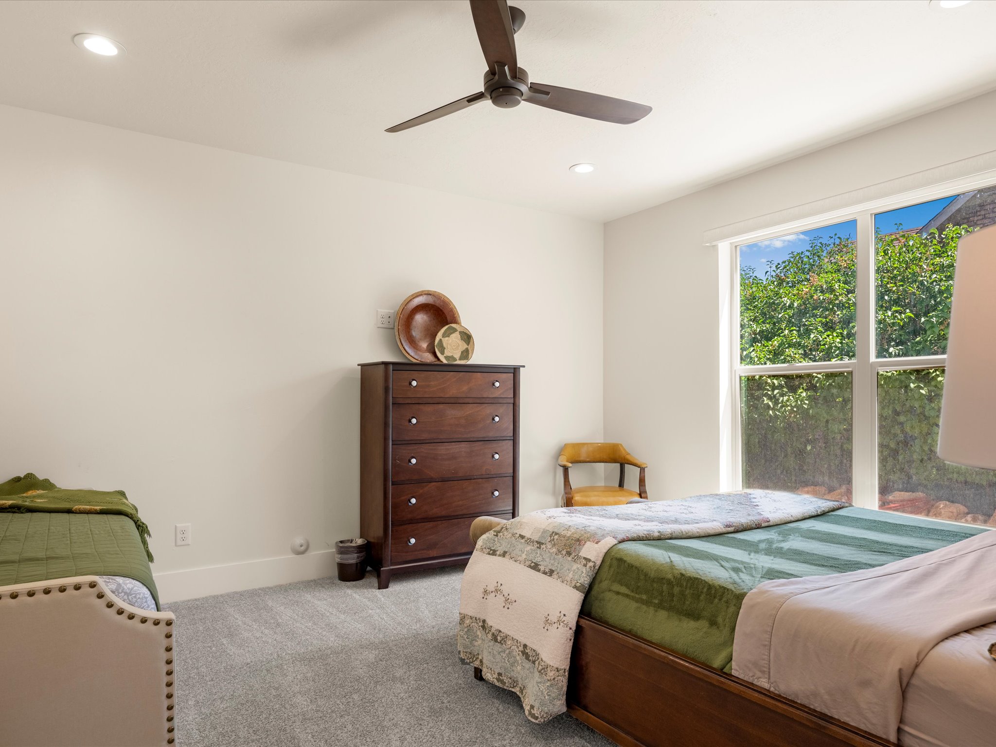 Bright room featuring recessed lighting, a ceiling fan, and a large window
