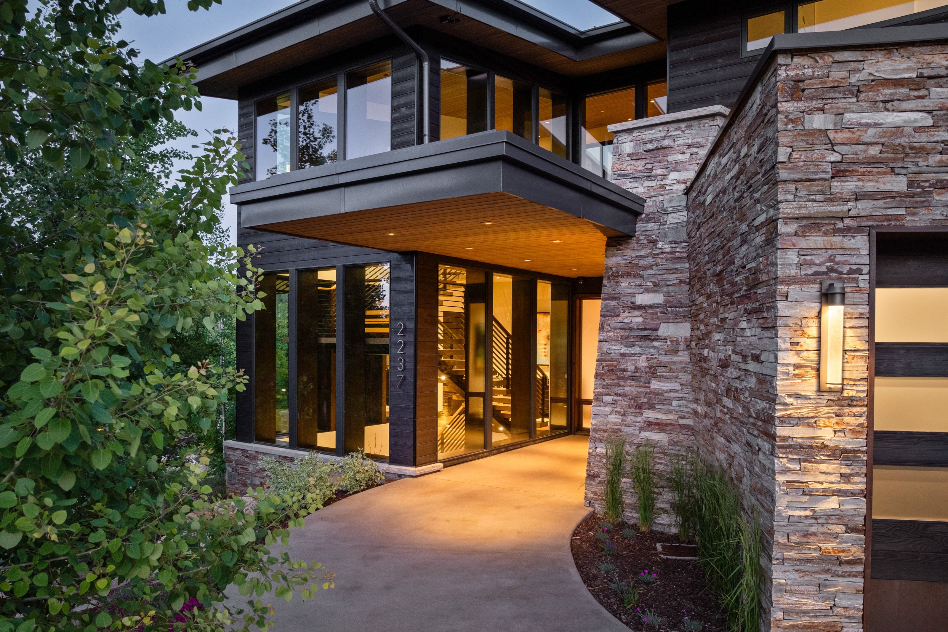 Modern exterior featuring stacked stone accents and dark horizontal siding