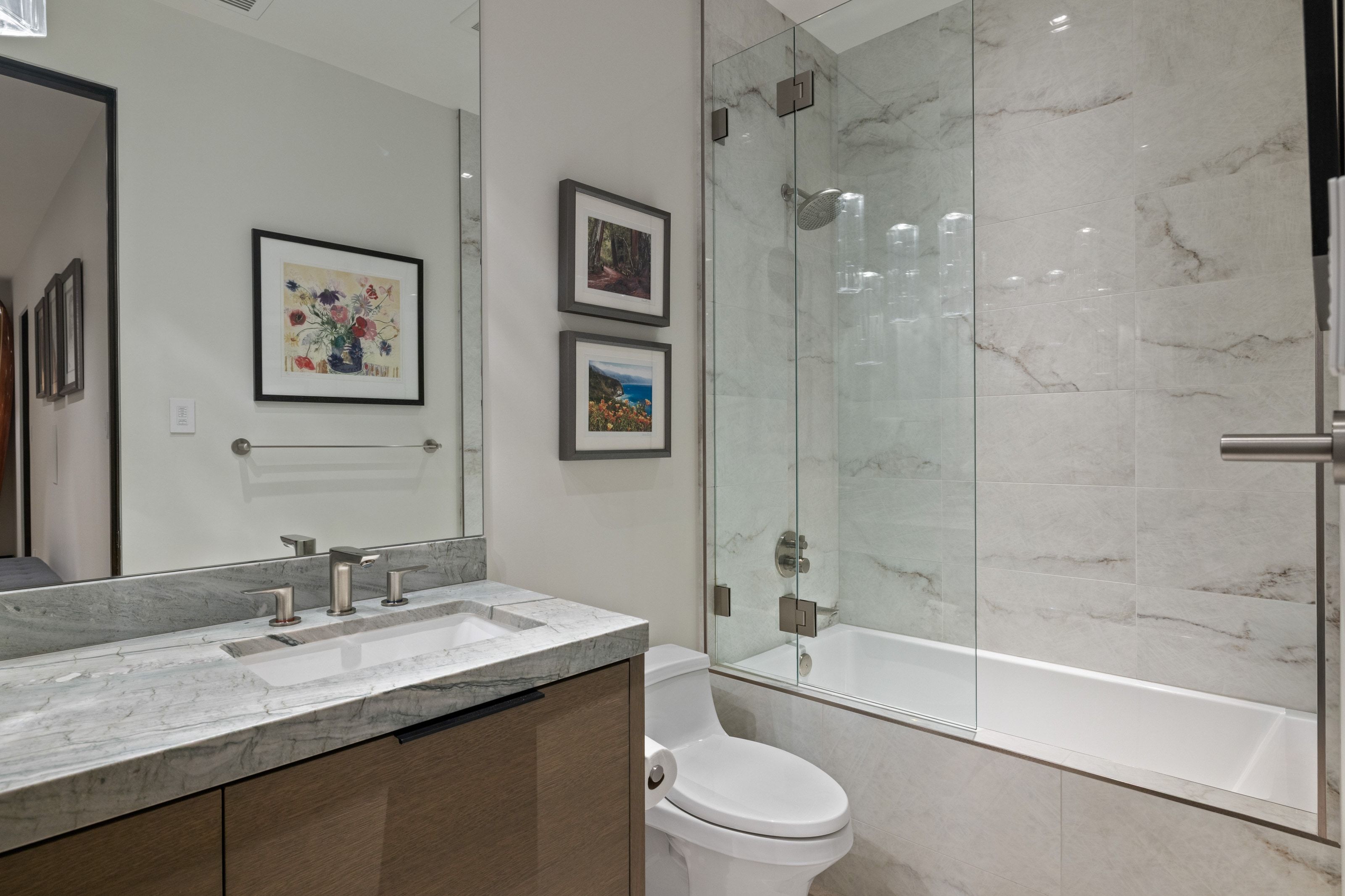Bathroom featuring a floating wood-finish vanity with a stone countertop and an undermount sink