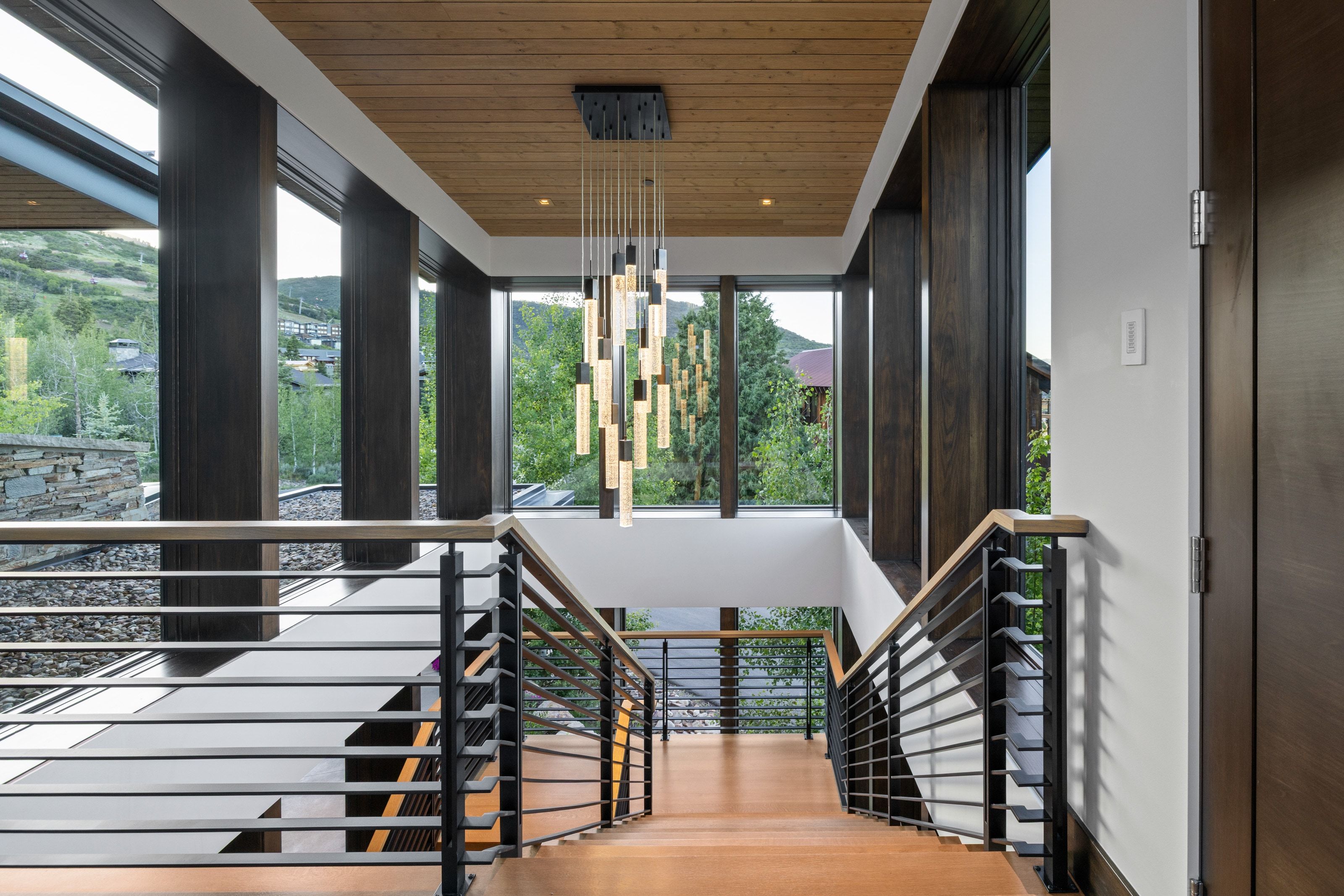 Open stairwell featuring hardwood treads and contemporary metal railings