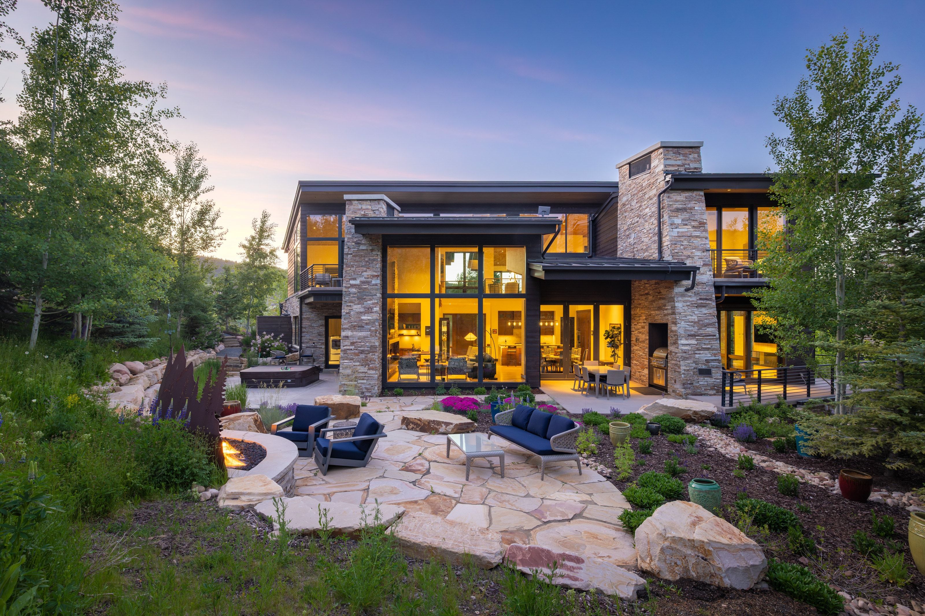 Contemporary residence featuring extensive stonework and large-pane windows