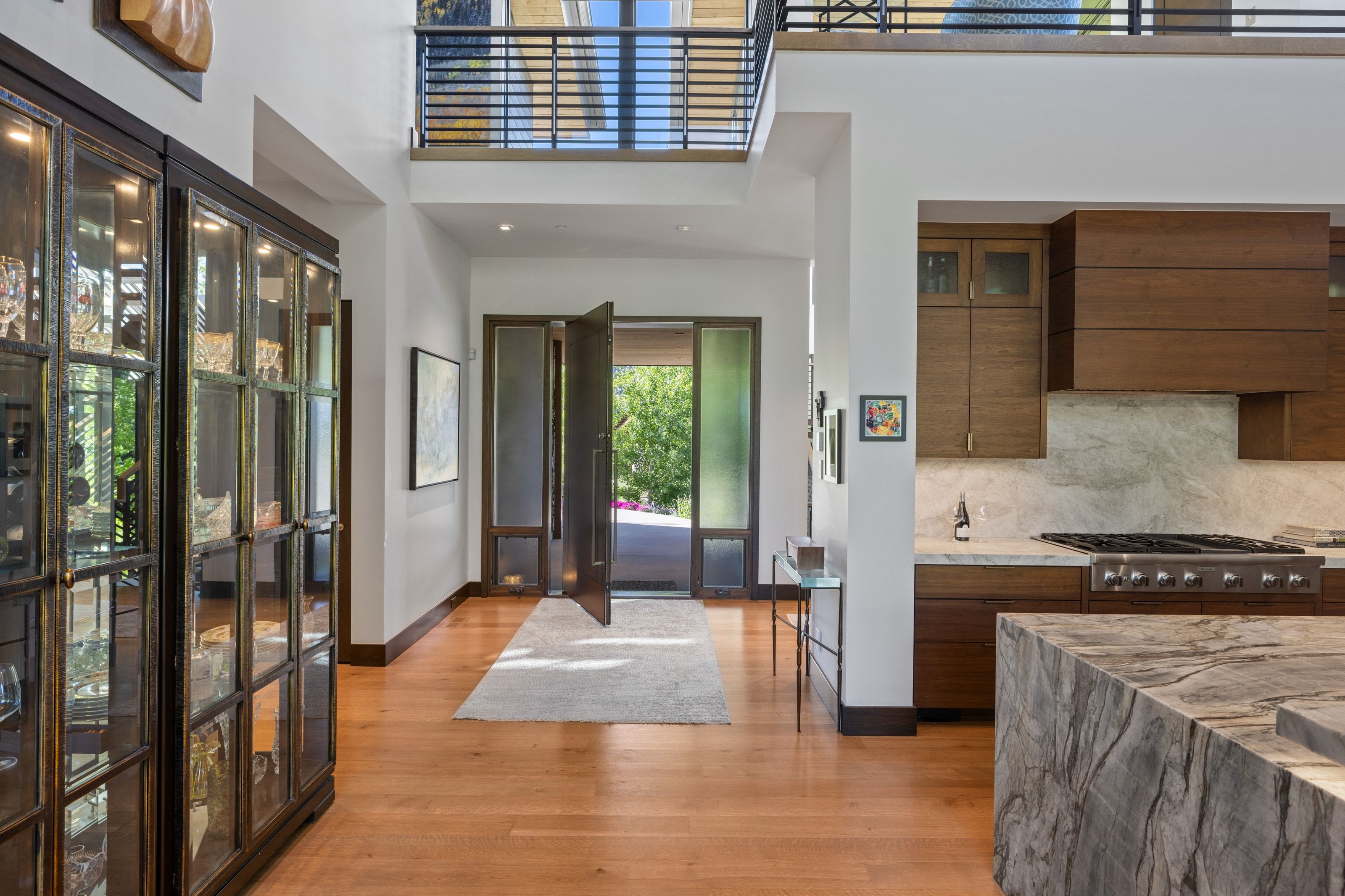 Double-height entryway with a floating balcony and hardwood flooring