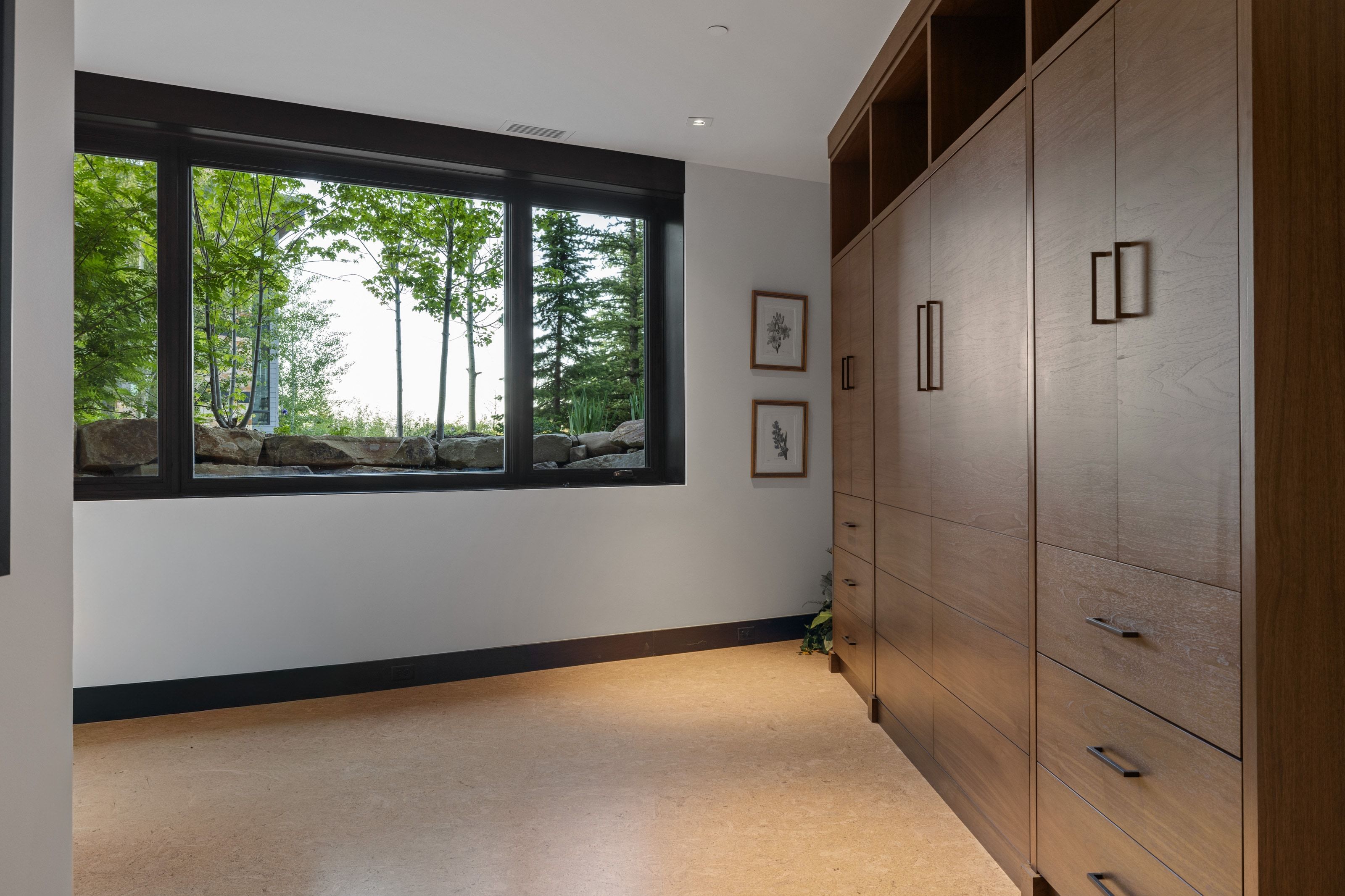 Expansive window framing mature trees and natural rock formations