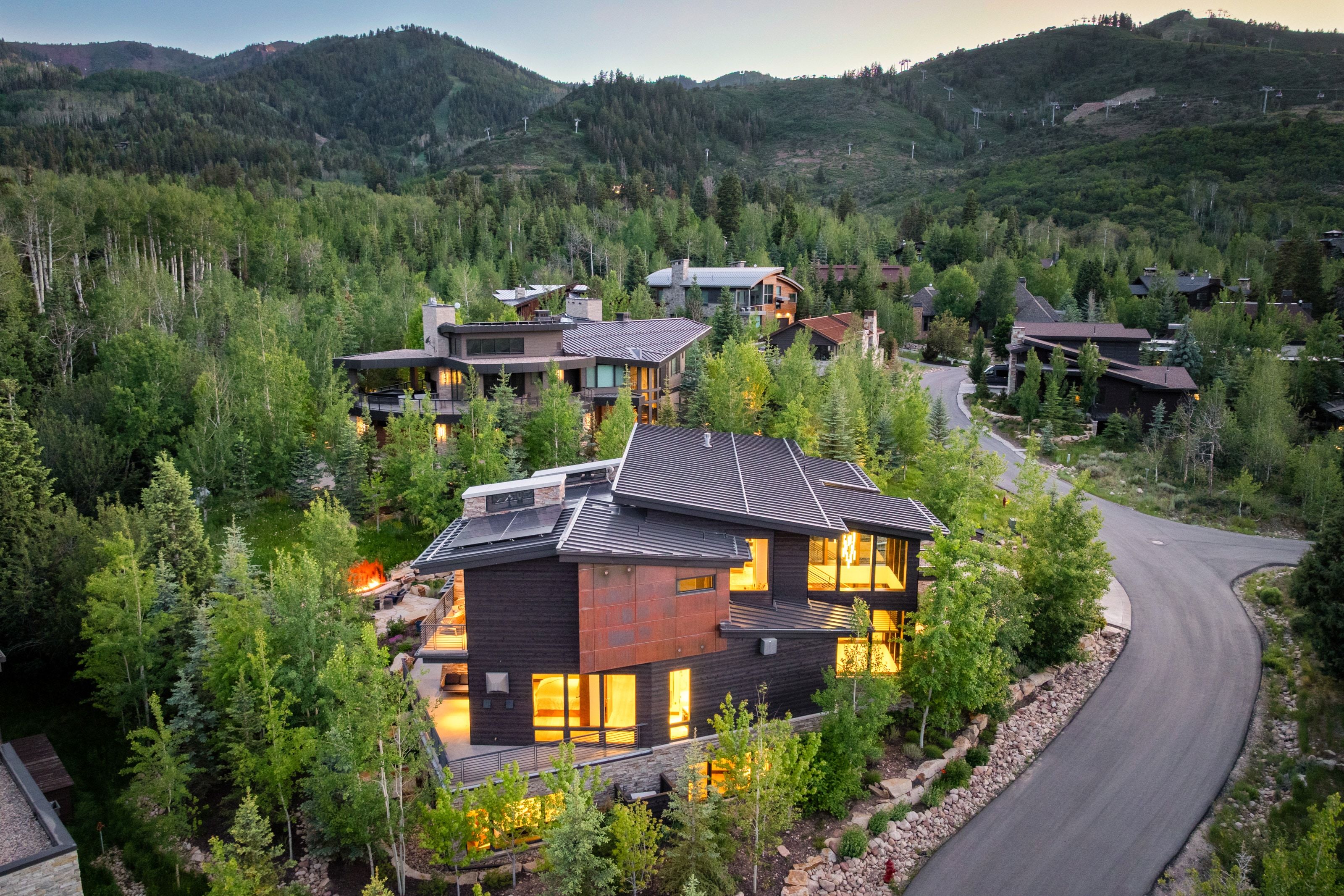 Modern architectural residence featuring multi-level dark siding and expansive window walls
