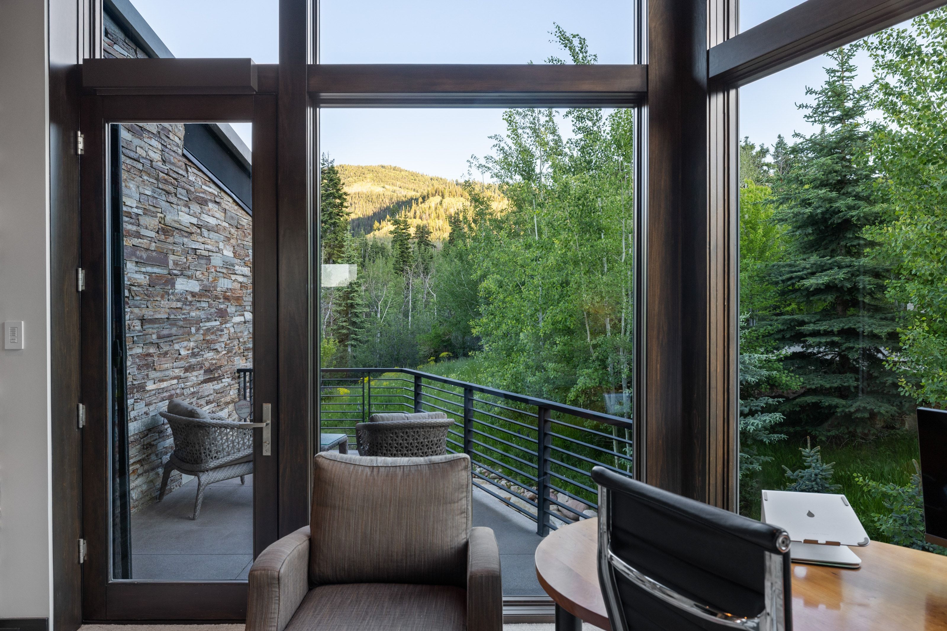 Expansive floor-to-ceiling windows with dark wood framing, providing abundant natural light