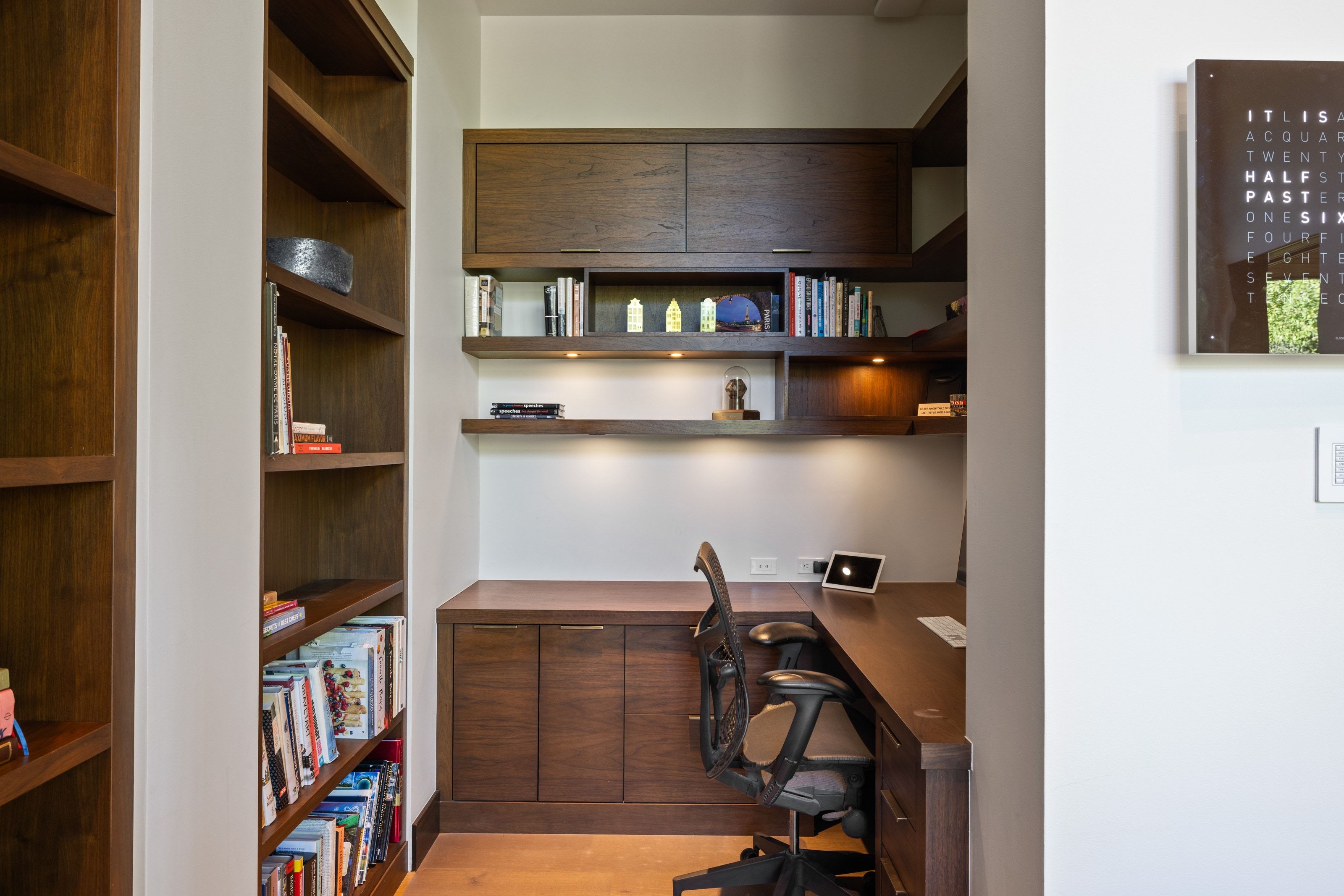 Custom built-in desk and cabinetry with recessed lighting, integrated shelving, and wood-finish flooring