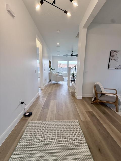 Open concept interior with light wood-finish flooring, recessed lighting, and a modern track lighting fixture
