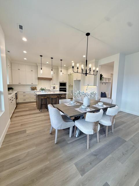 Open-concept kitchen and dining area featuring light wood-finish flooring