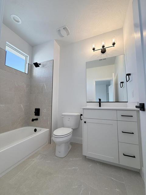White vanity with a rectangular basin, black faucet, and coordinating hardware