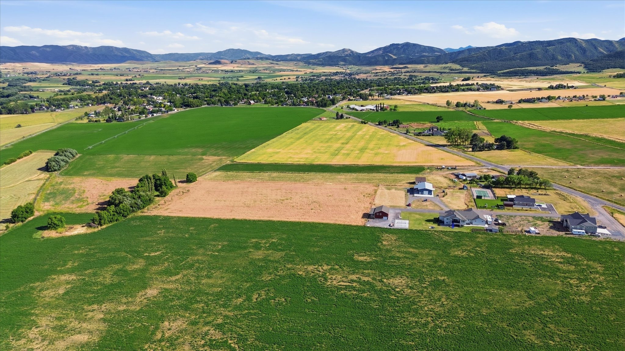 Expansive agricultural landscape with varied crop fields and distant mountains