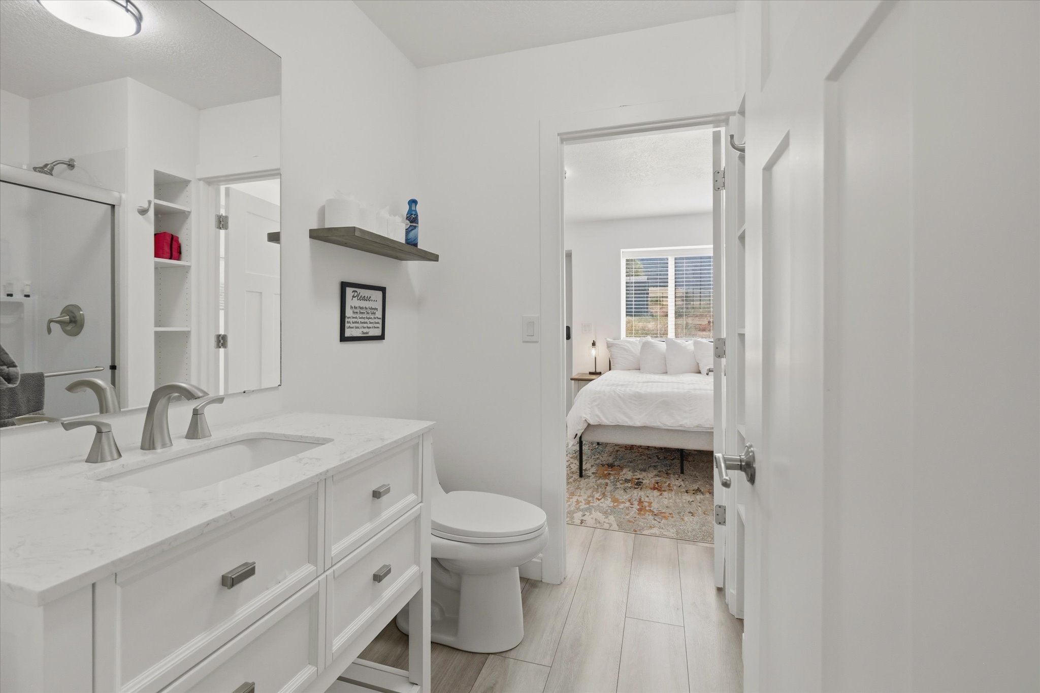 Bathroom featuring a white vanity with a rectangular undermount sink, brushed nickel faucet, and white countertop