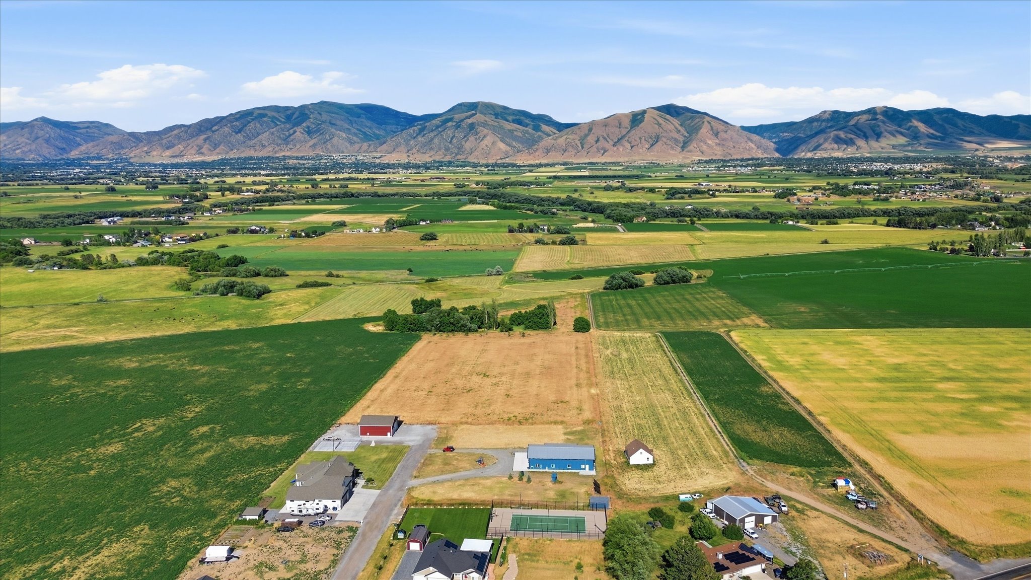 Expansive rural landscape featuring a mix of agricultural fields and residential properties