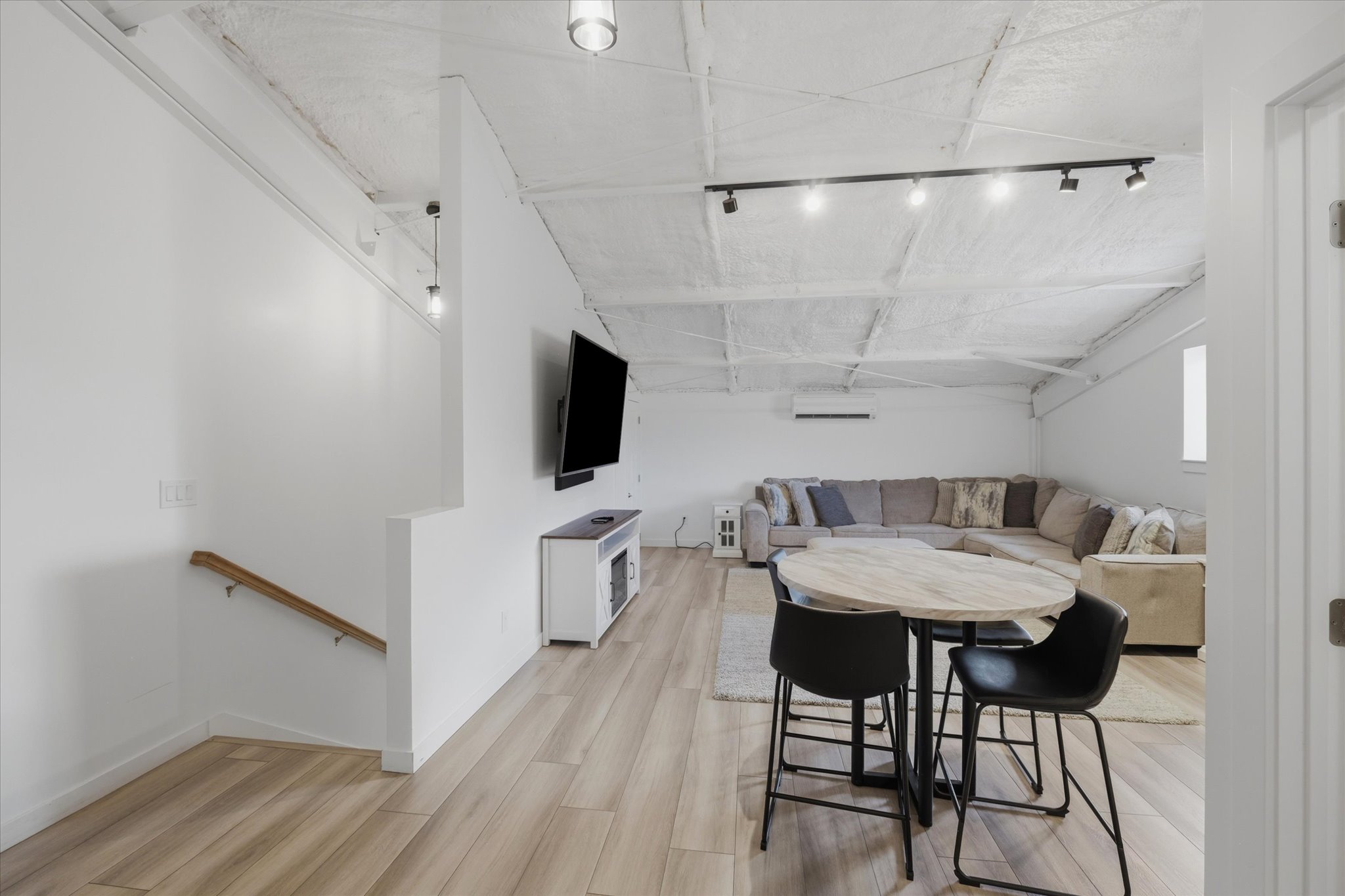 Open concept room featuring wood-finish flooring, white walls, and a textured ceiling