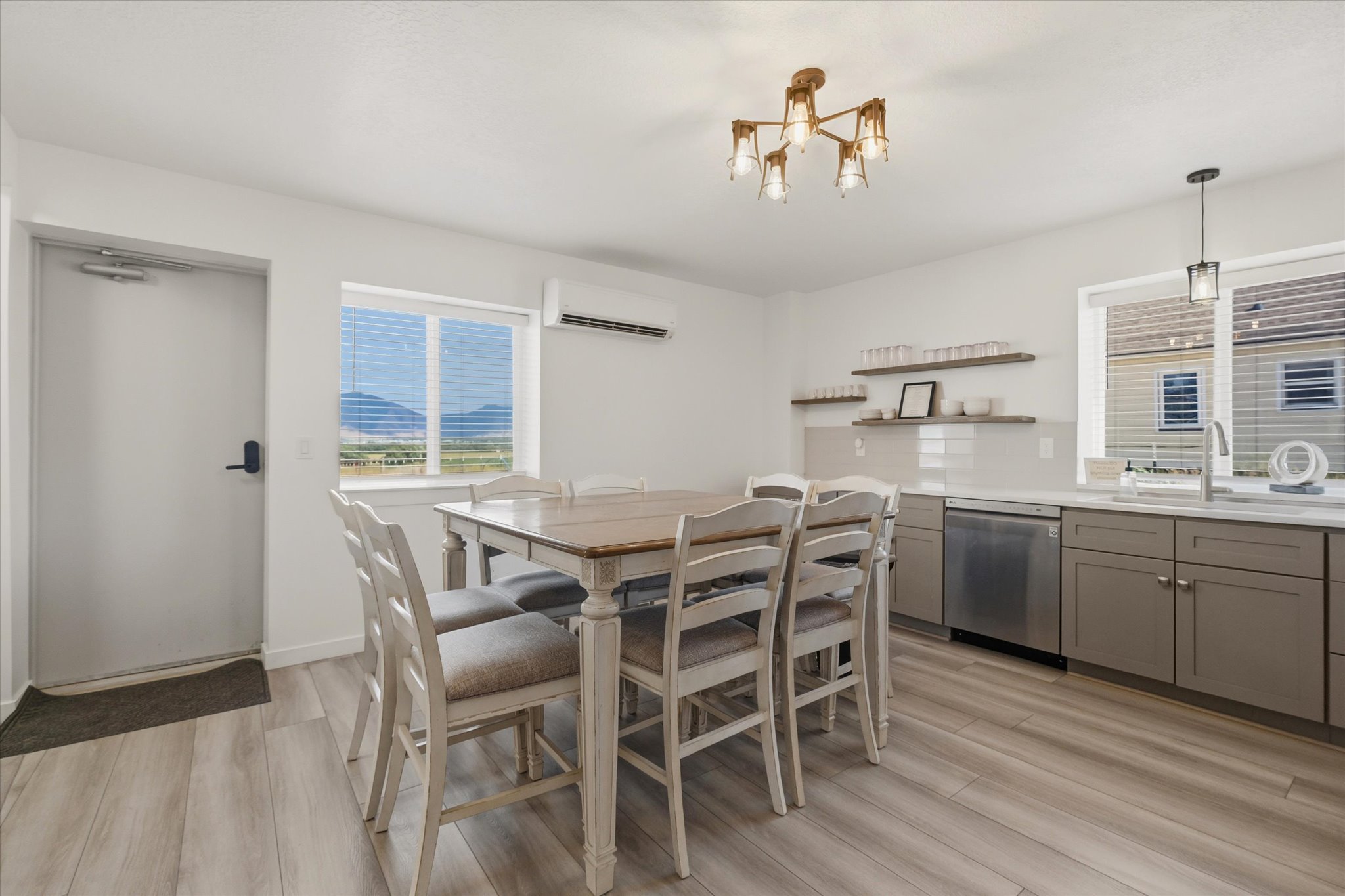 Bright interior featuring light wood-finish flooring, a contemporary ceiling light fixture, and a window with mountain scenery