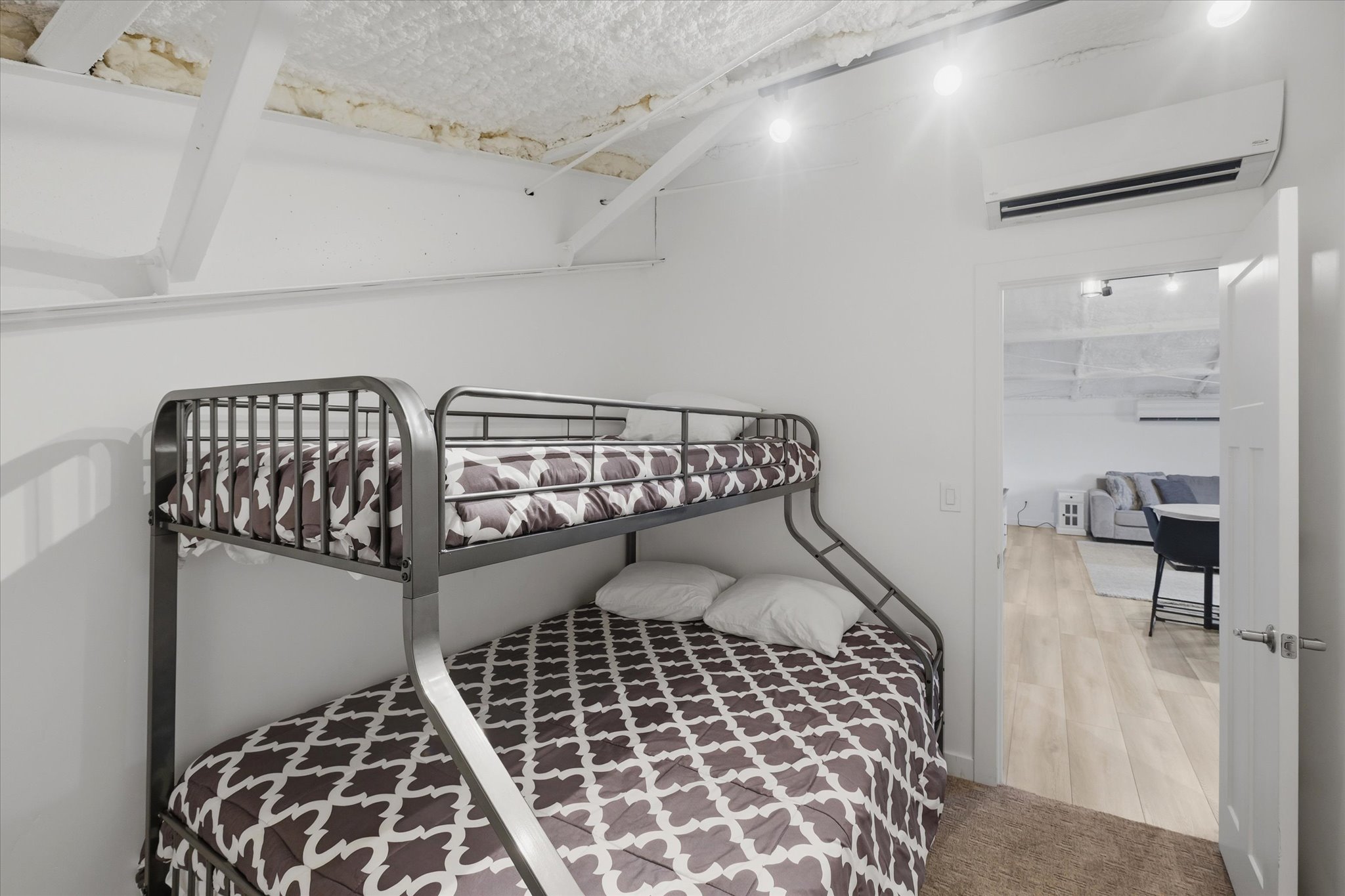White walls featuring exposed ceiling beams and recessed lighting