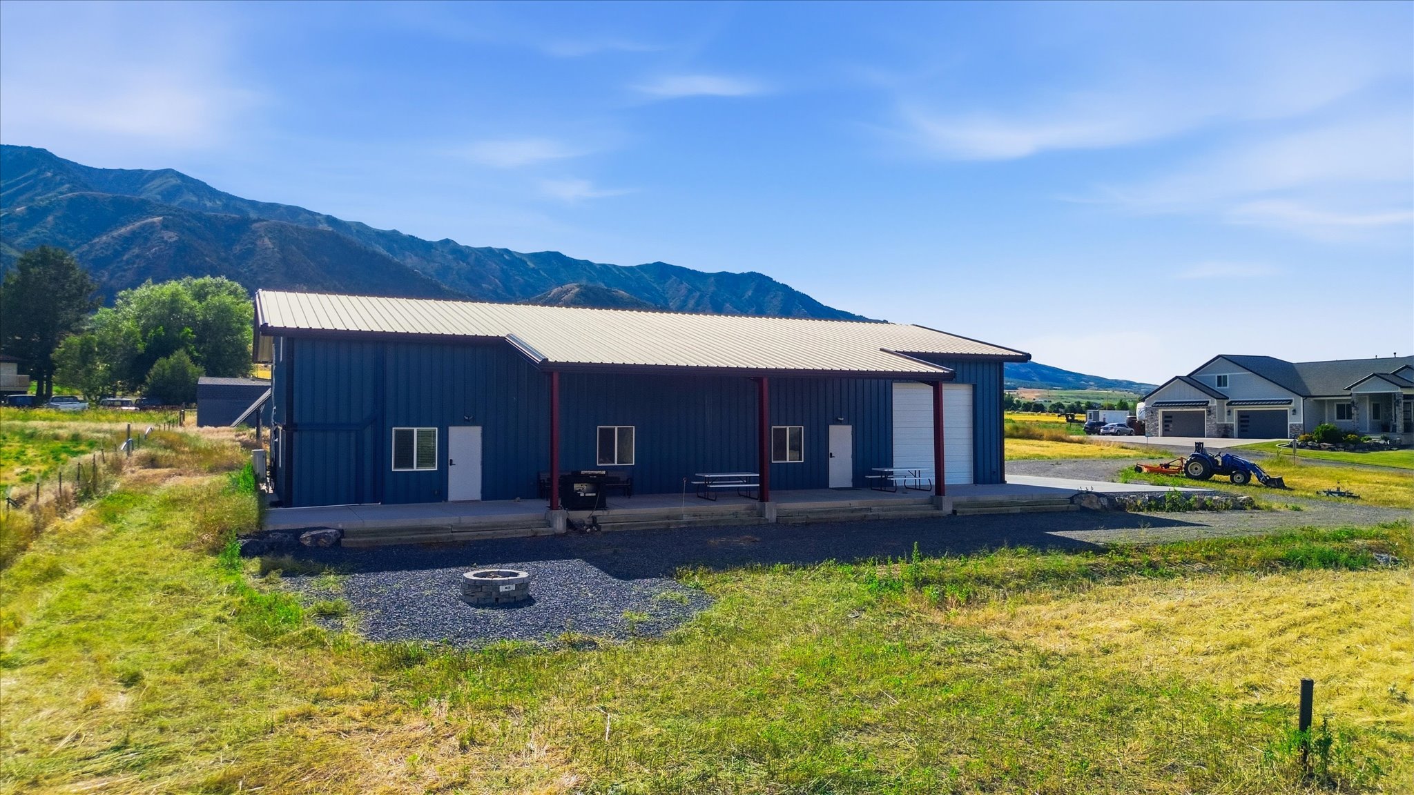 Blue metal building with a light-colored metal roof and red support beams