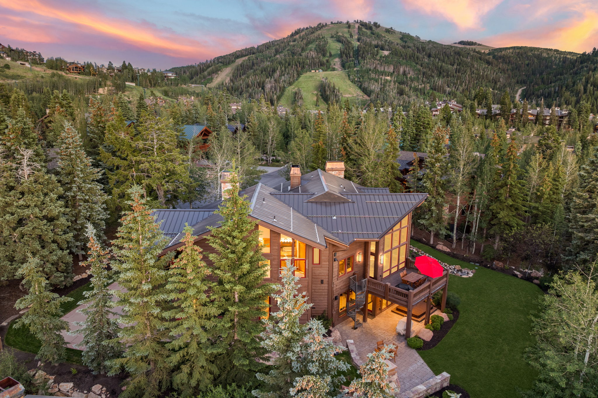 Wood-sided residence featuring a multi-level design, extensive window detailing, a metal roof, and an elevated deck