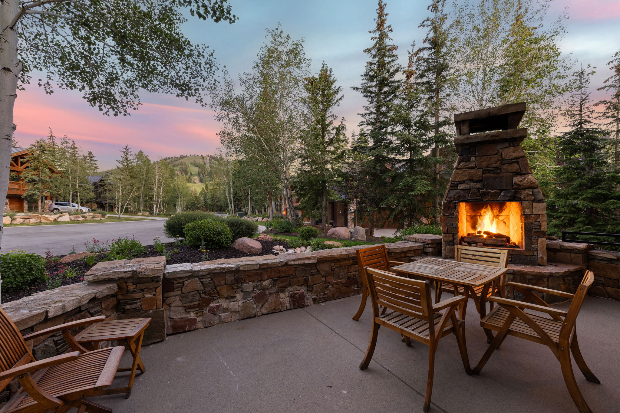 Outdoor patio featuring a stone-clad fireplace and matching stone retaining walls