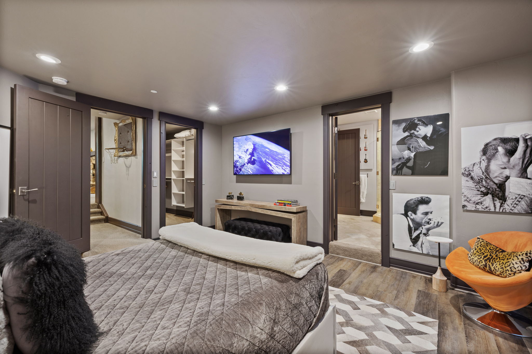 Recessed lighting illuminates wood-finish flooring with a geometric area rug