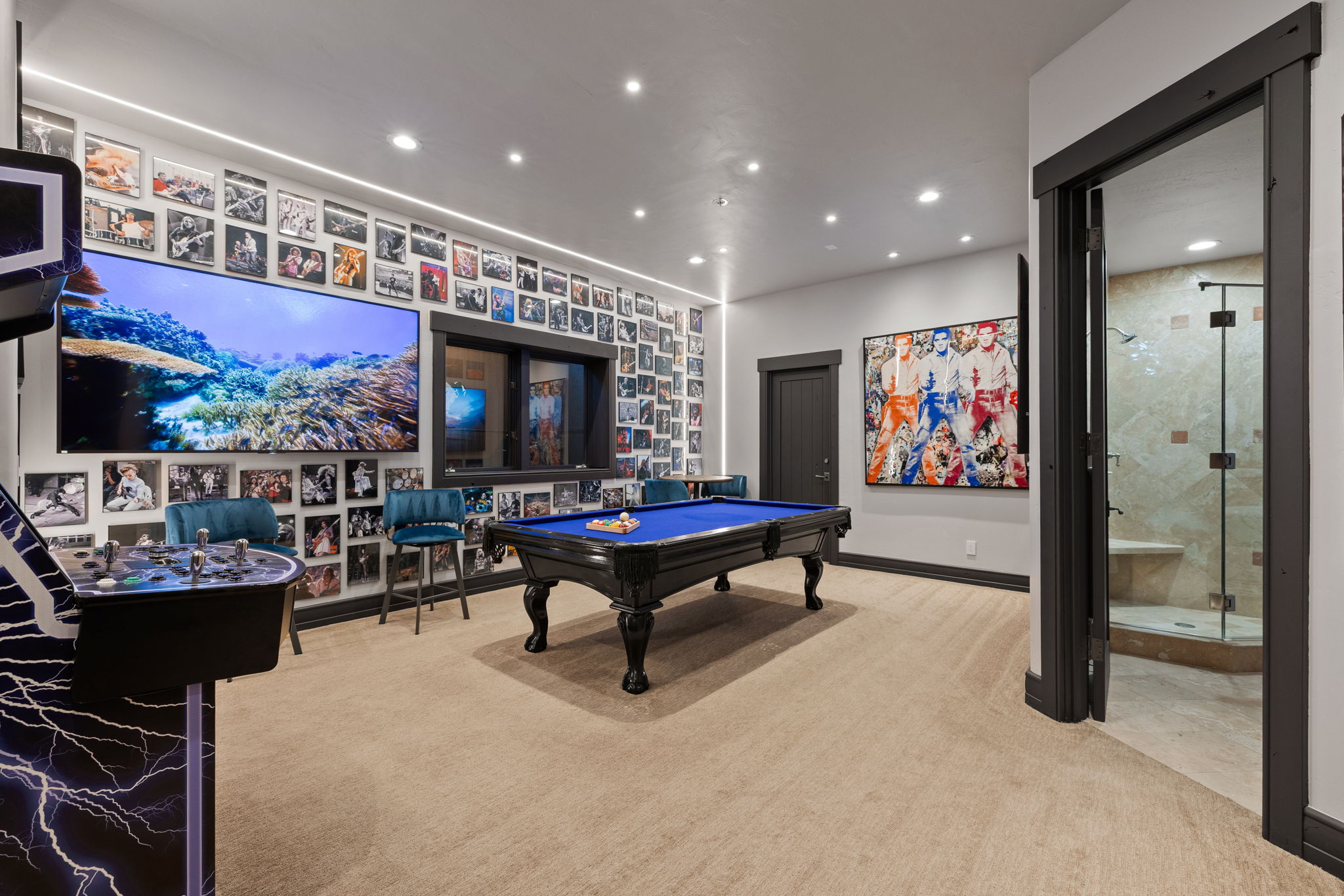 Carpeted entertainment area featuring a full-size billiards table, recessed lighting, and a large wall-mounted display