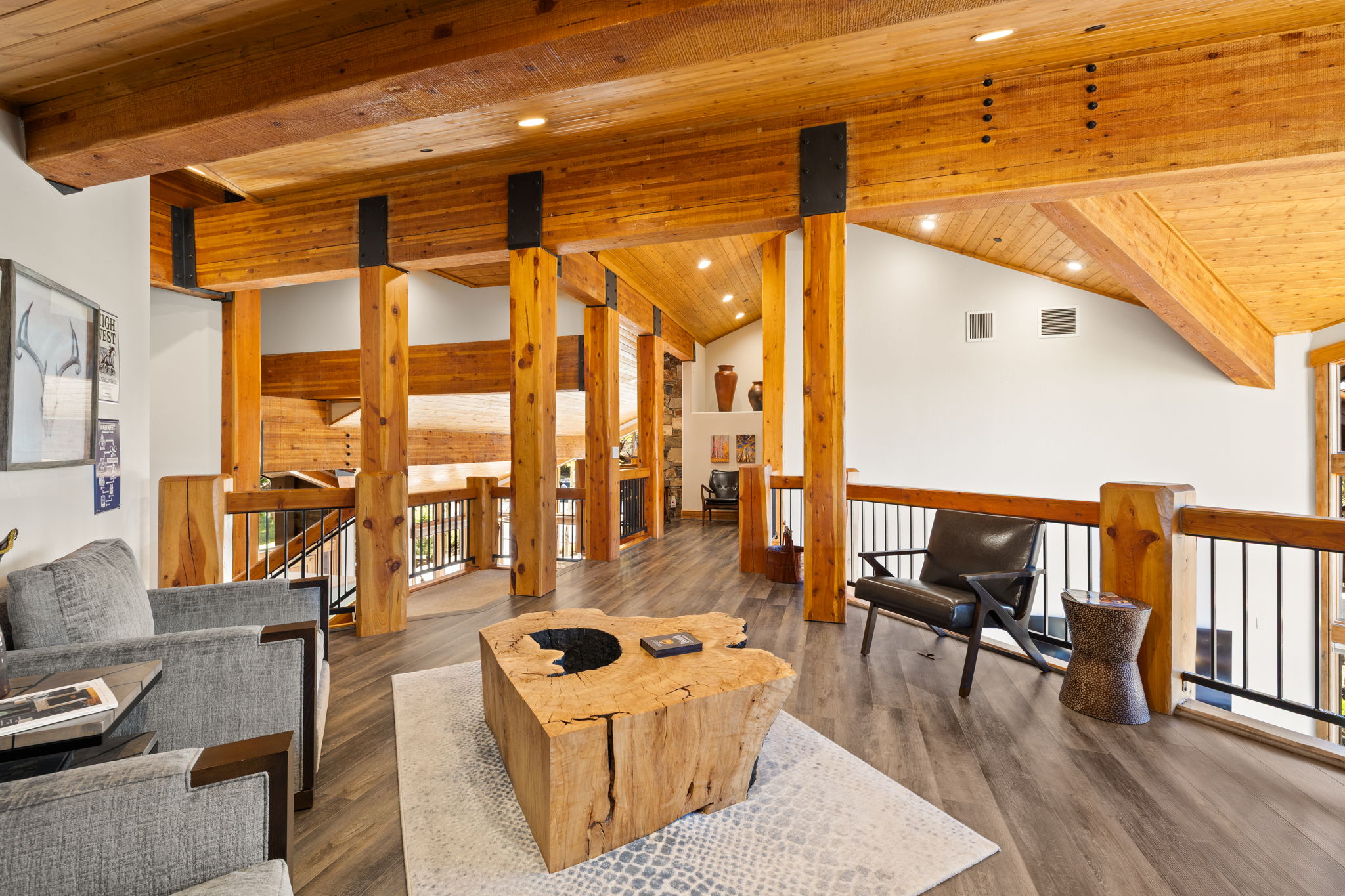 Exposed timber beam construction featuring vaulted wood-paneled ceilings, recessed lighting, and wood-finish flooring
