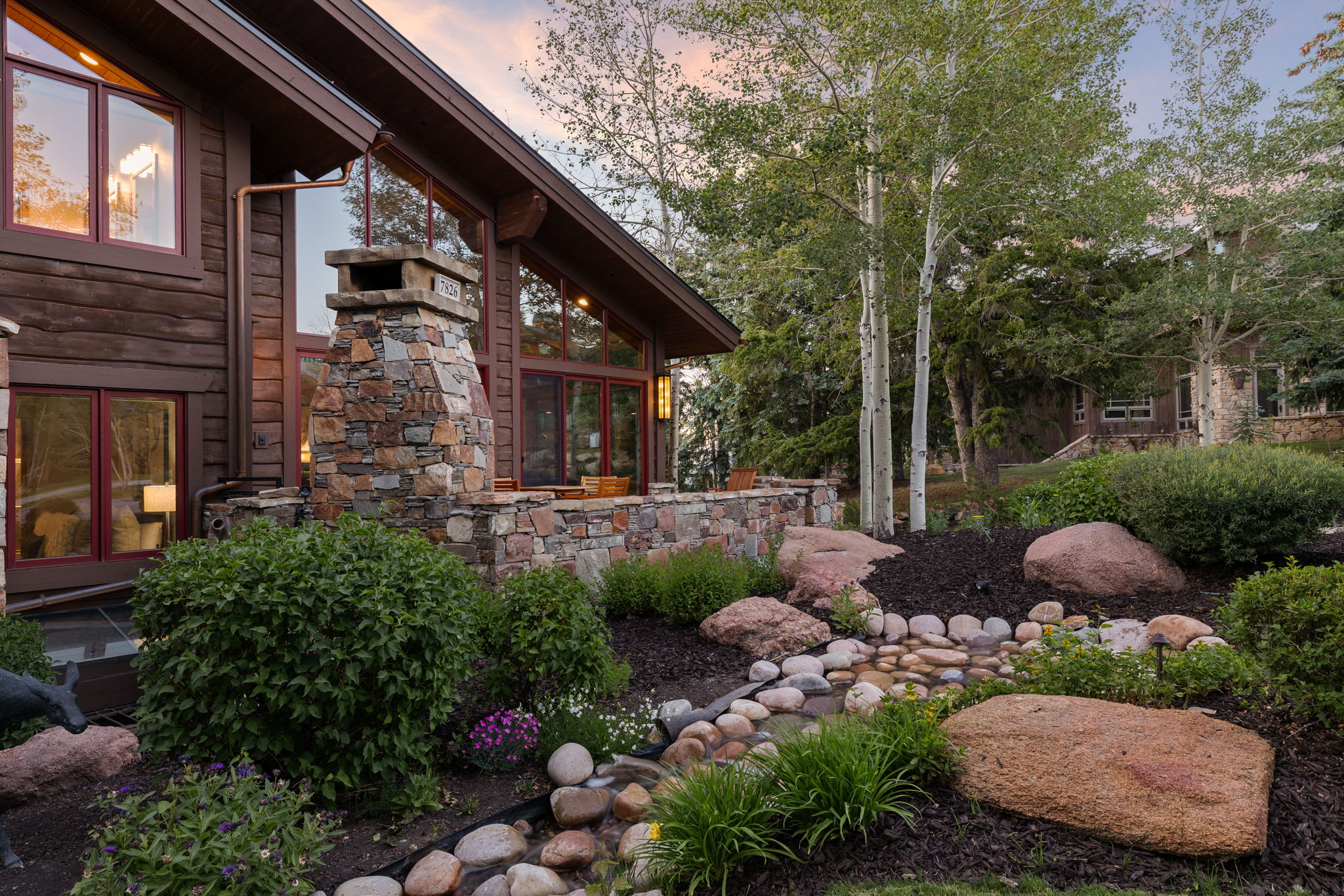 Log-sided exterior featuring extensive stonework and large windows