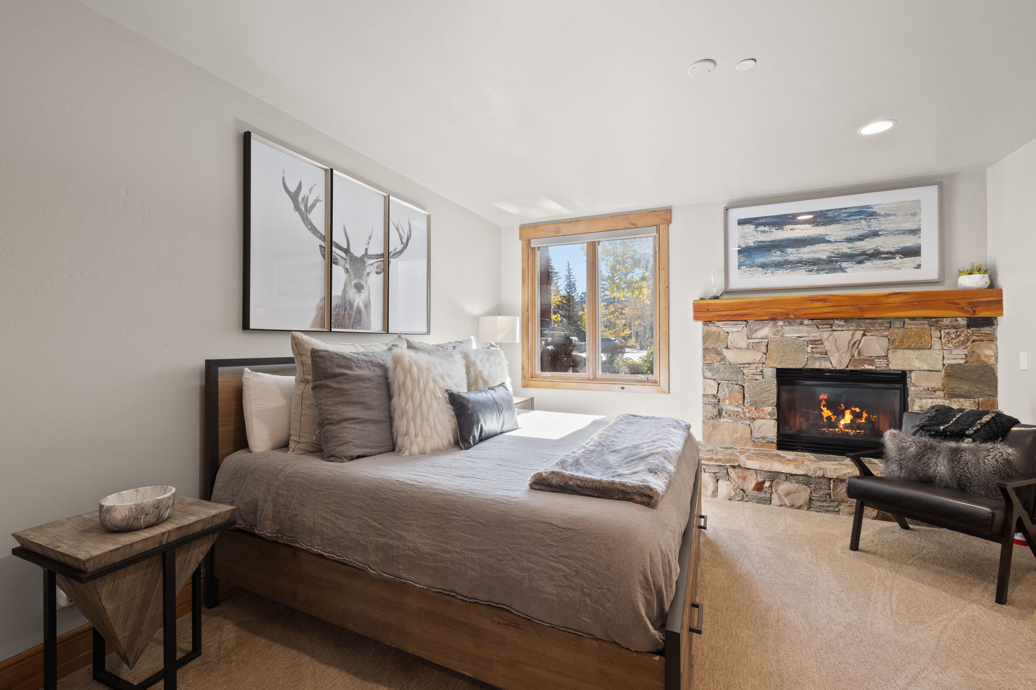 Corner stone fireplace with a substantial wood mantel, wood-framed window, recessed ceiling lighting, and carpeted flooring