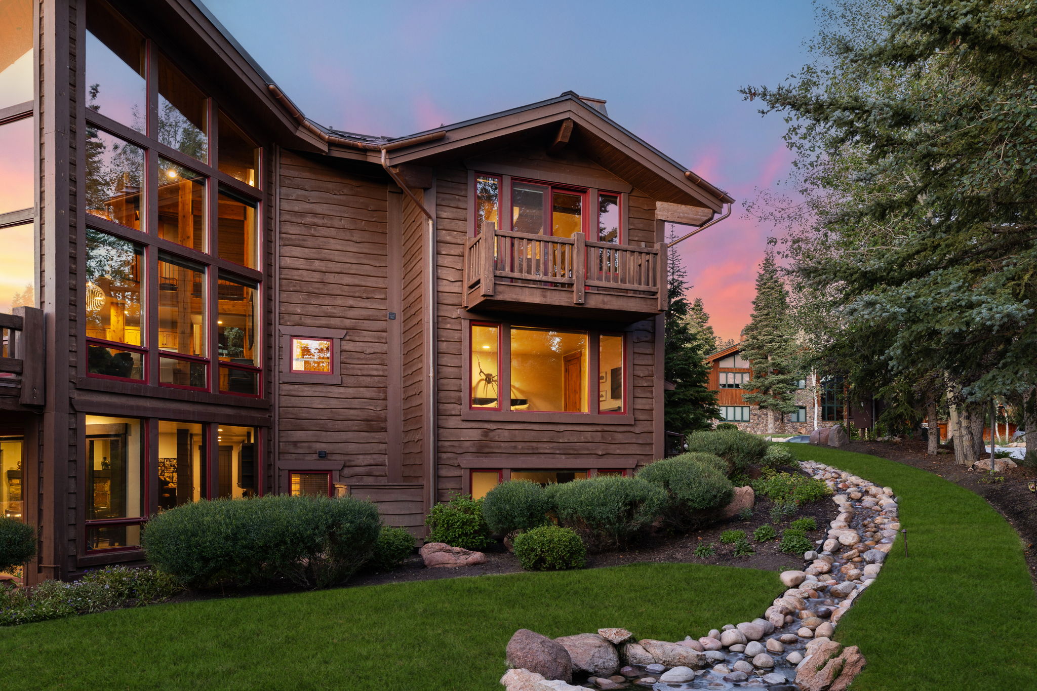 Wood-clad exterior with extensive window features and a second-story balcony
