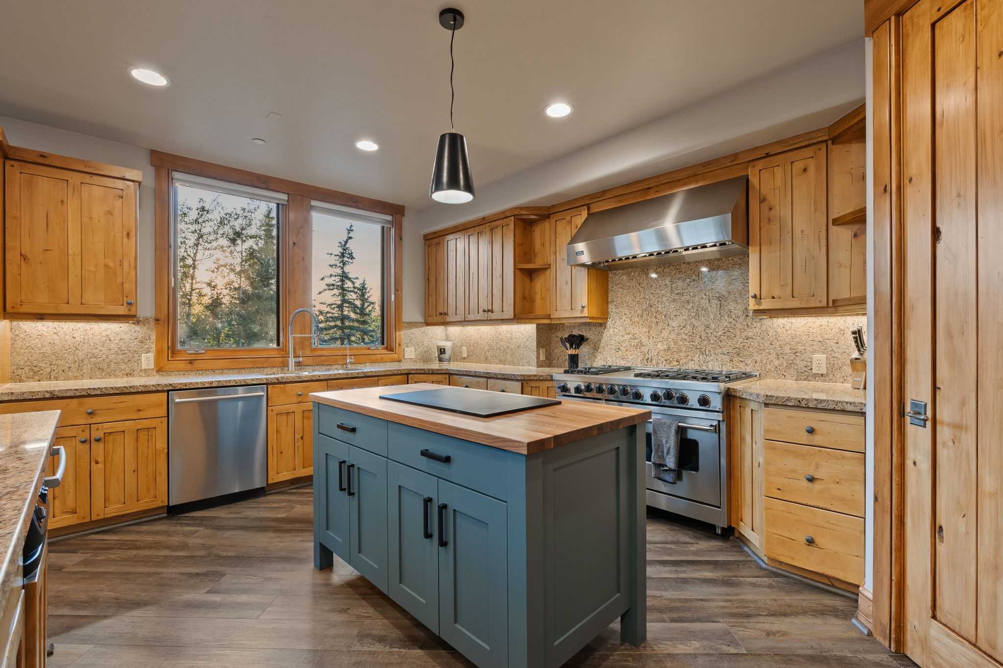 Kitchen featuring wood-finish flooring, natural wood cabinetry, and granite countertops