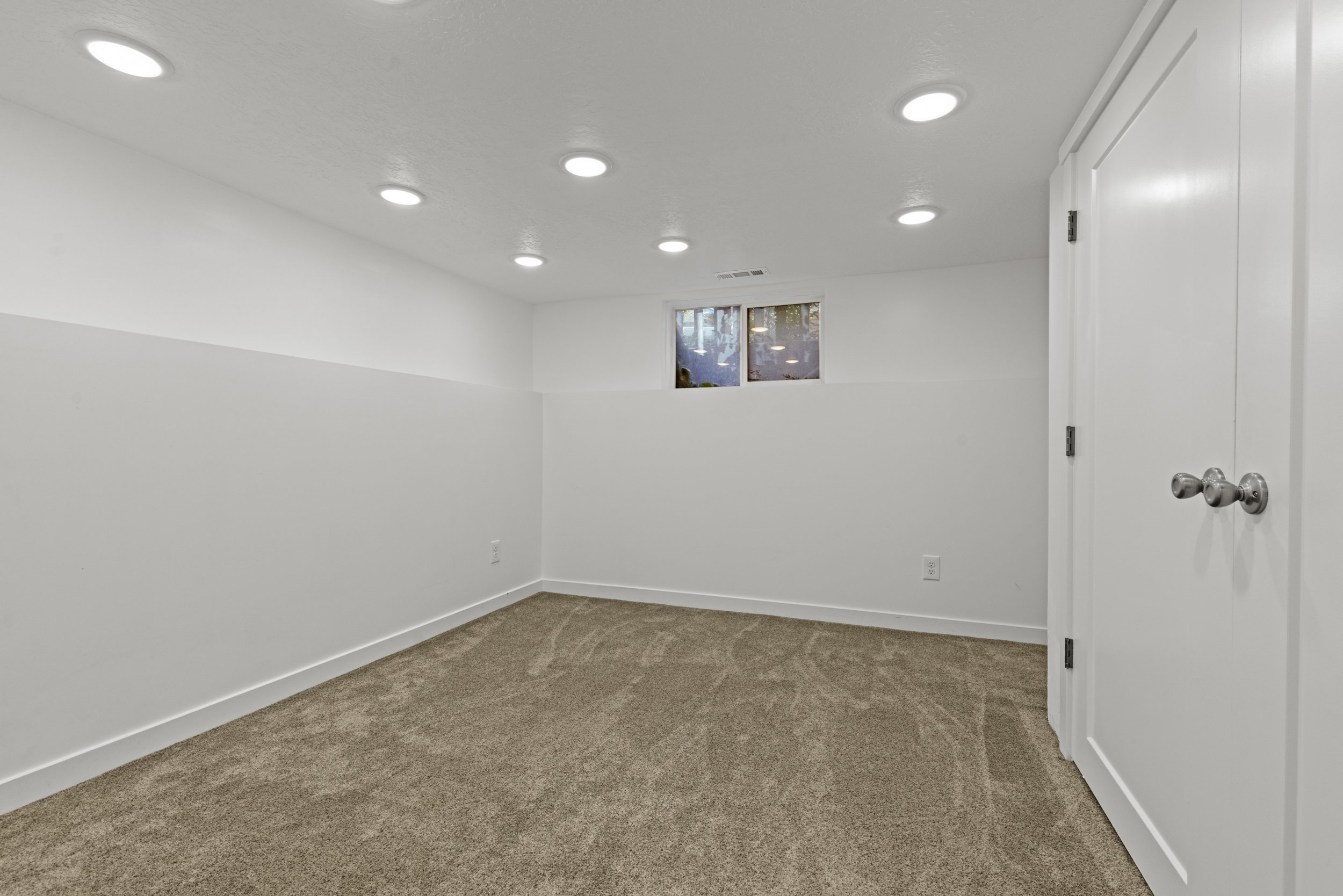 Neutral-toned carpeting complements the white walls and trim in this interior space
