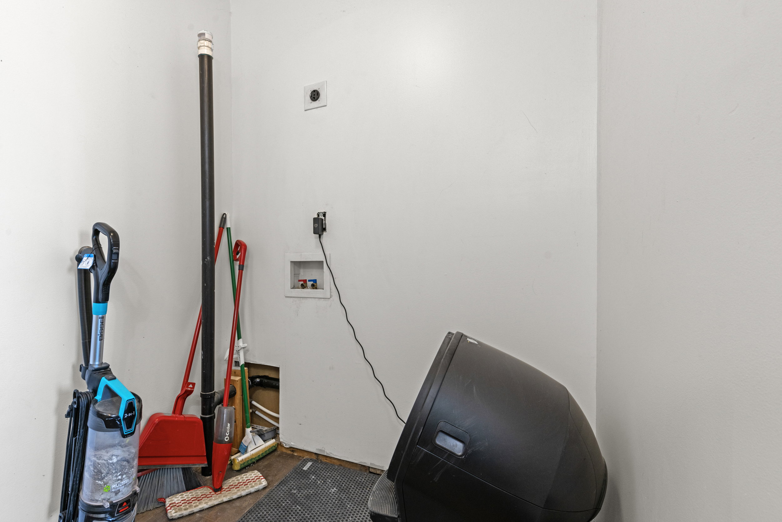 Utility area featuring white walls and a visible water hookup